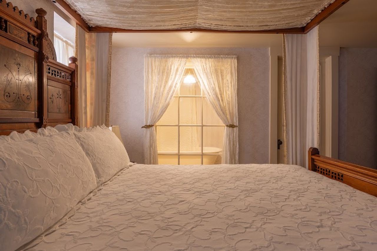 Photo of Martine Inn - Eastlake Room with a king-size bed on a raised dais and extra-long claw-foot tub