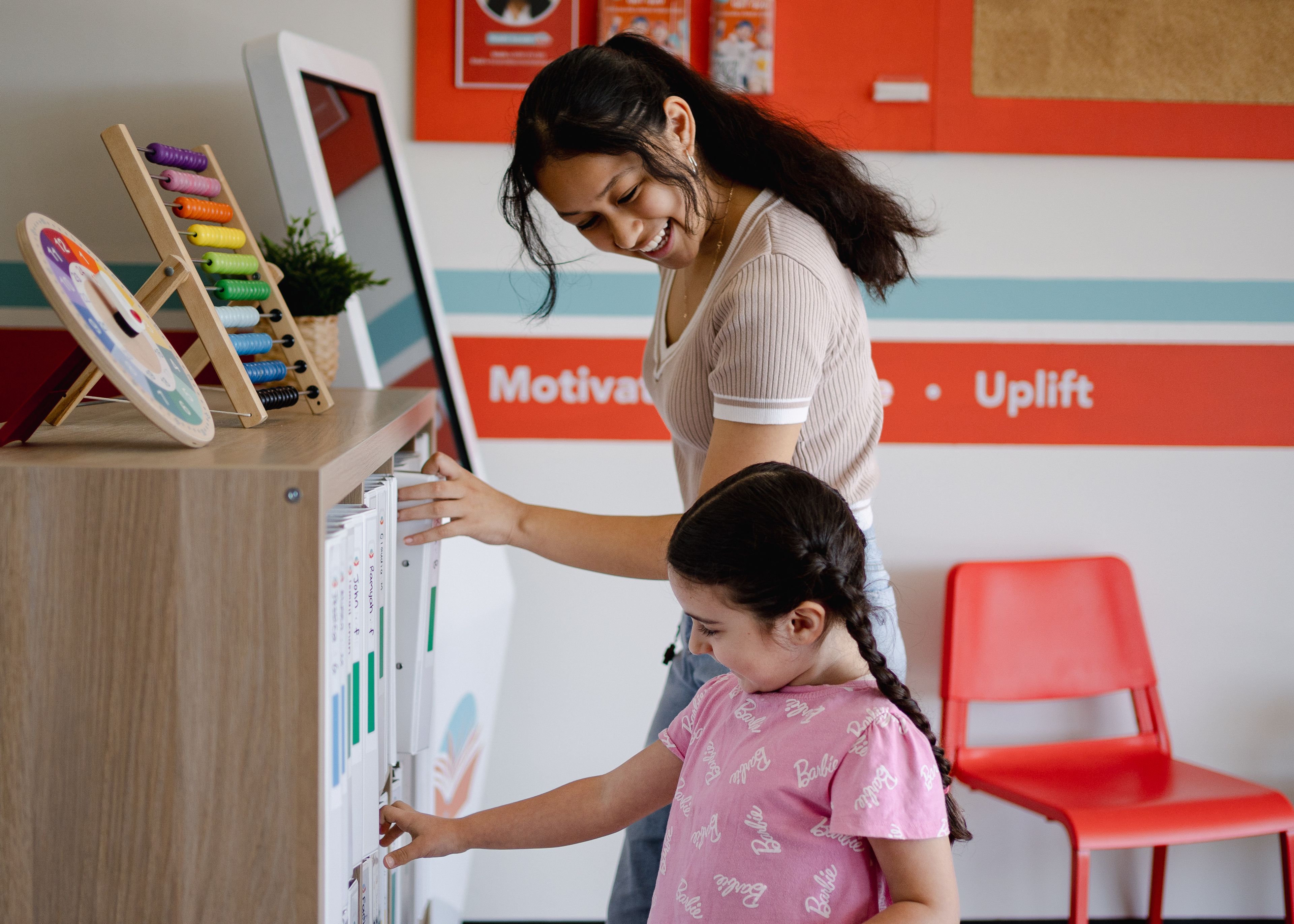 a woman and a little girl are standing next to each other in a waiting room .