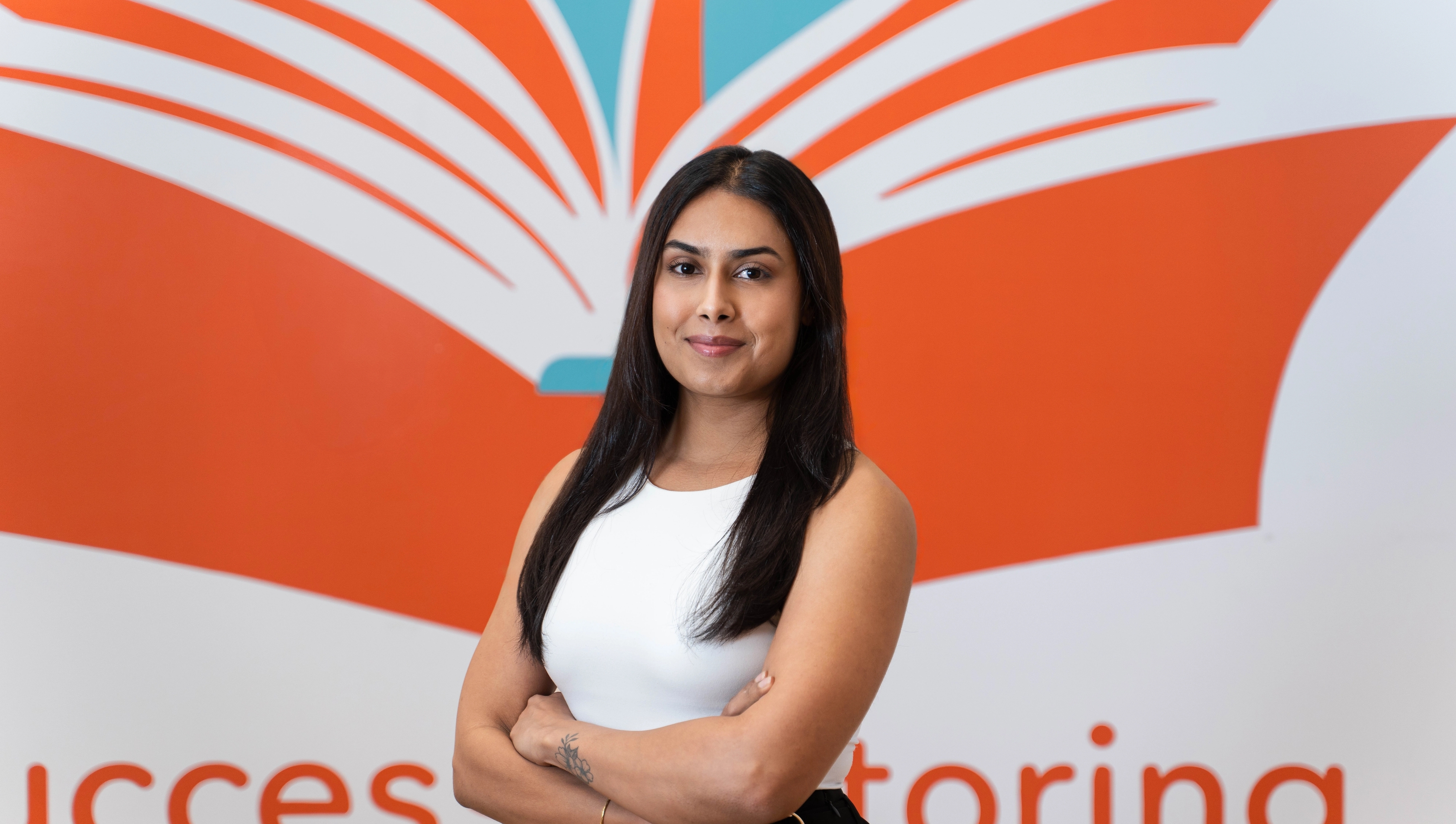 a woman is standing in front of a wall with a book on it .