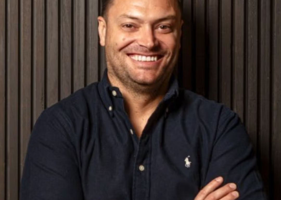 a man with his arms crossed is wearing a polo shirt