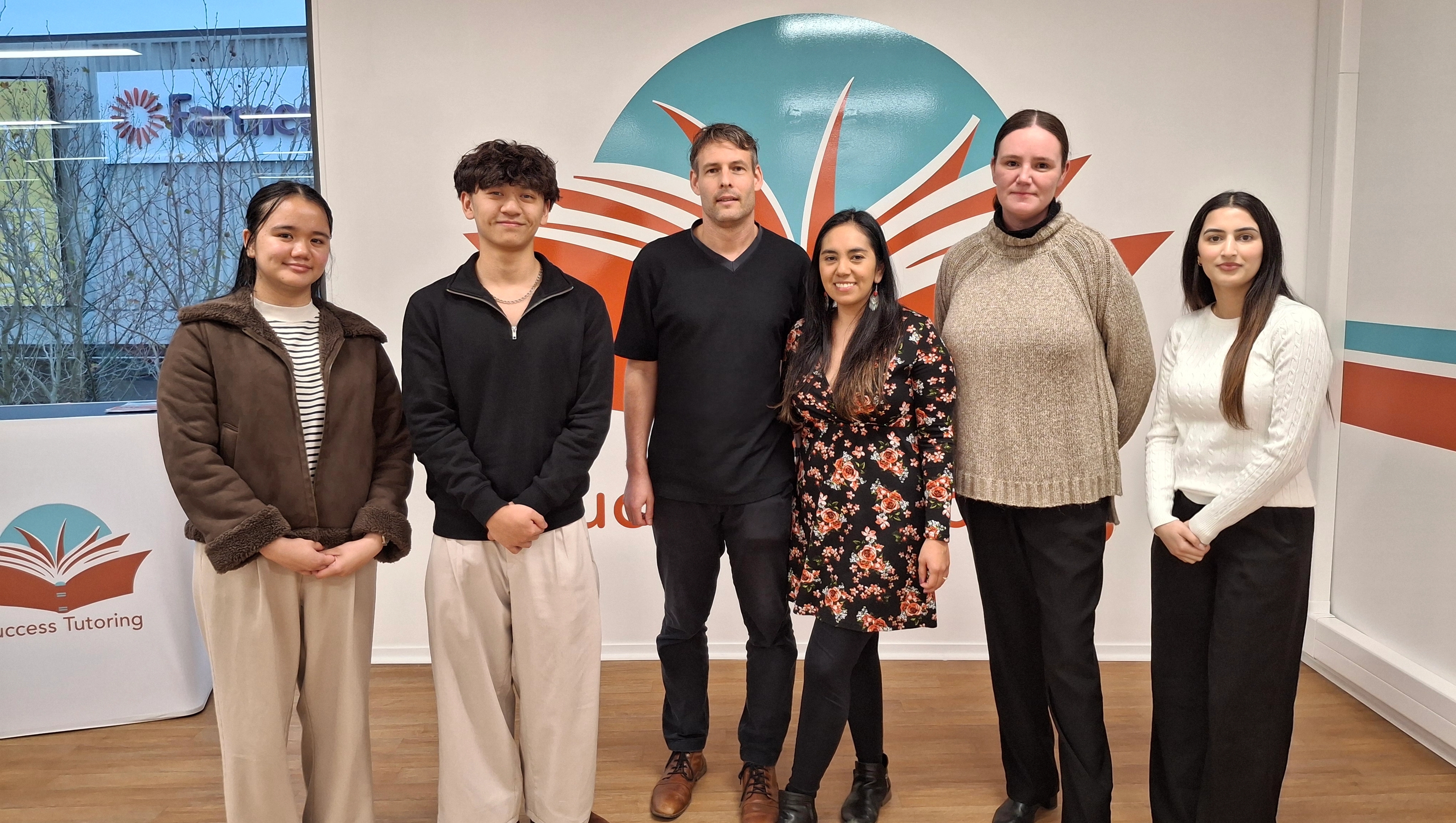 a group of people are posing for a picture in a room .