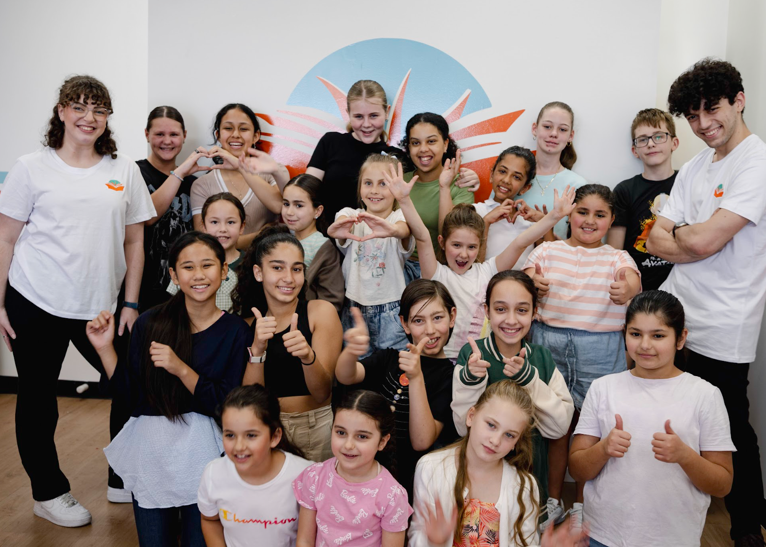 a group of children are posing for a picture and one girl is wearing a champion shirt