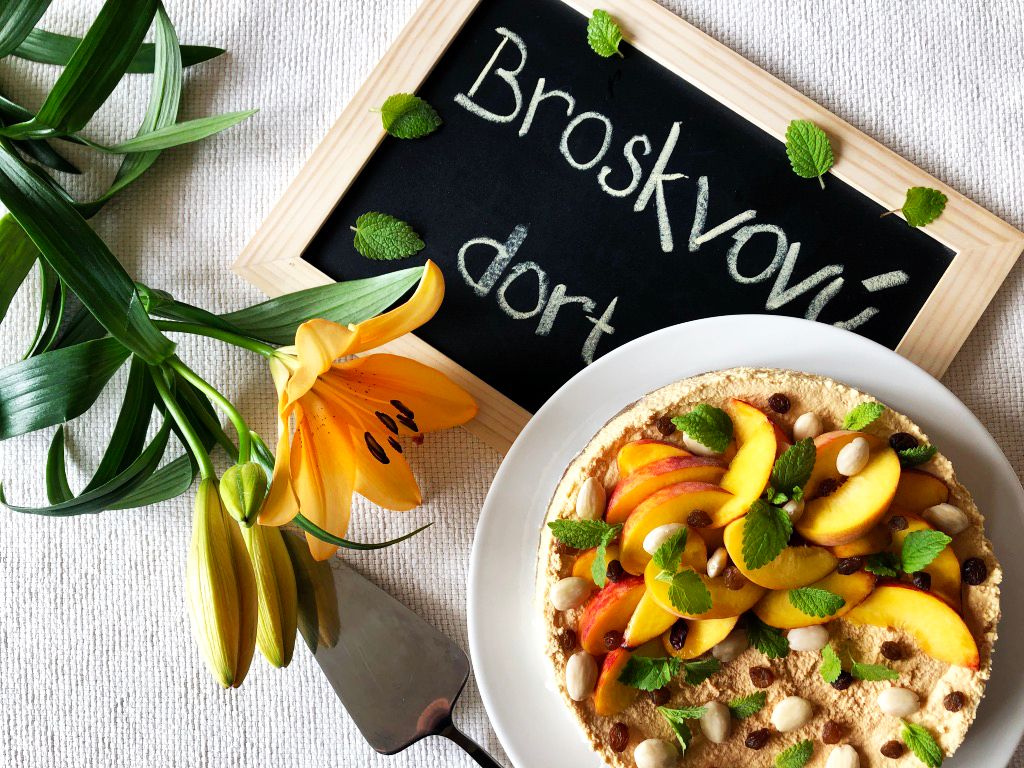 Nepečený broskvový dort s korpusem ze sezamových semínek a rozinek. Svěží, sladký a zdravý.