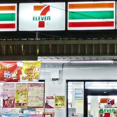 A 7-Eleven store in Thailand with scooter standing outside.