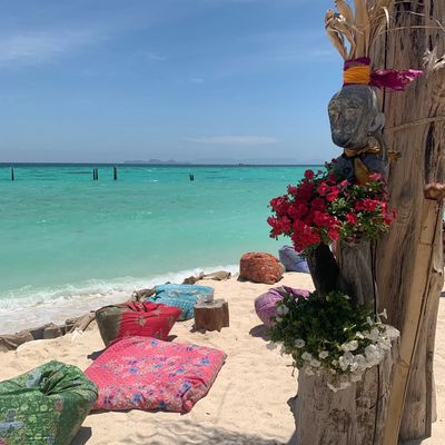 Clear turquoise water and colorful beach cushions at Koh Lipe’s North Point Beach, surrounded by tropical plants and a serene atmosphere. Ideal place for sunbathing and relaxing by the sea.