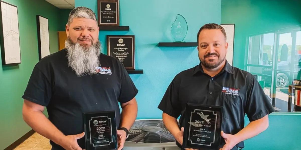See Jeremy and Charles from SS&B Heating & Cooling proudly displaying their hard-earned Trane awards, showcasing their dedication to excellence in the HVAC industry.