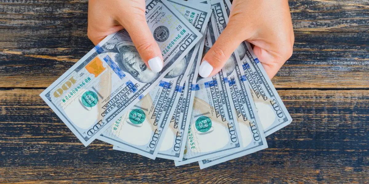 Close-up of hands holding a stack of cash, symbolizing savings from HVAC upgrades in Springfield, MO.
