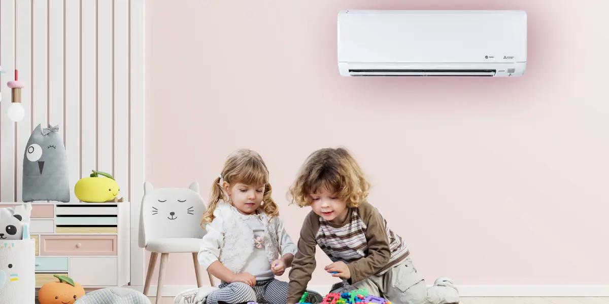 Two young children playing with toys in a room with a Trane mini split air conditioner mounted on the wall.