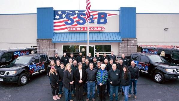 Group photo in front of SS&B Heating & Cooling store entrance.