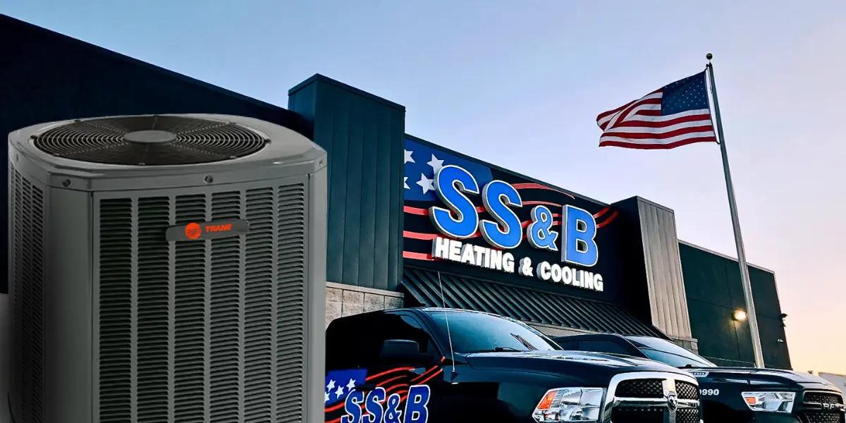 Trane 17 Multi-Speed Heat Pump unit in front of SS&B Heating & Cooling building with American flag at sunset in Springfield, MO.