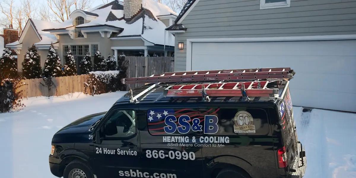 SS&B Heating & Cooling service van parked outside a snow-covered home, showcasing 24-hour HVAC service readiness for winter heating emergencies in Springfield, MO.