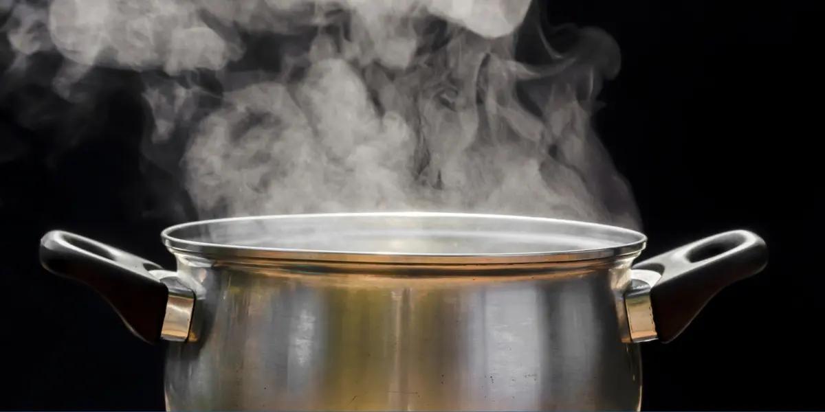 An old-fashioned method for adding humidity to a room, showing a pot of water boiling on a stove, with steam rising from it.