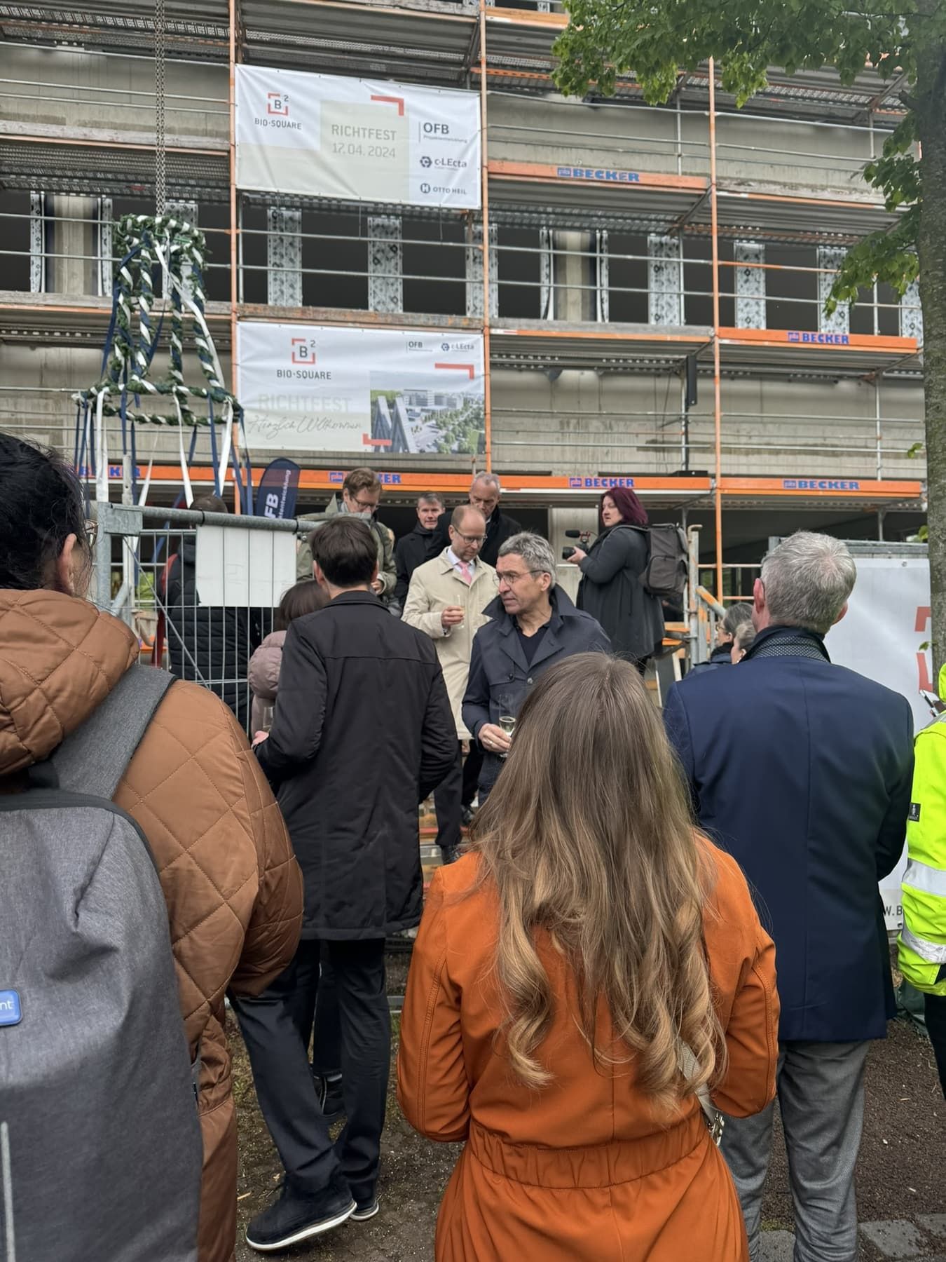 Richtfest BioSquare am 17. April 2024 – Gäste vor dem Gerüst mit dem Richtkranz