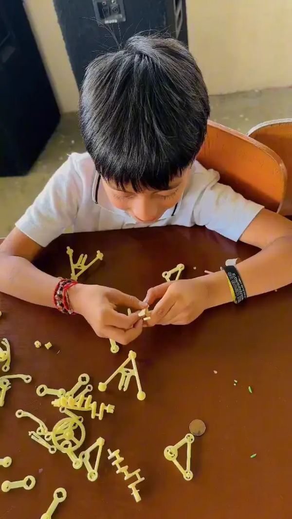 Estudiante armando una estructura con piezas de construcción