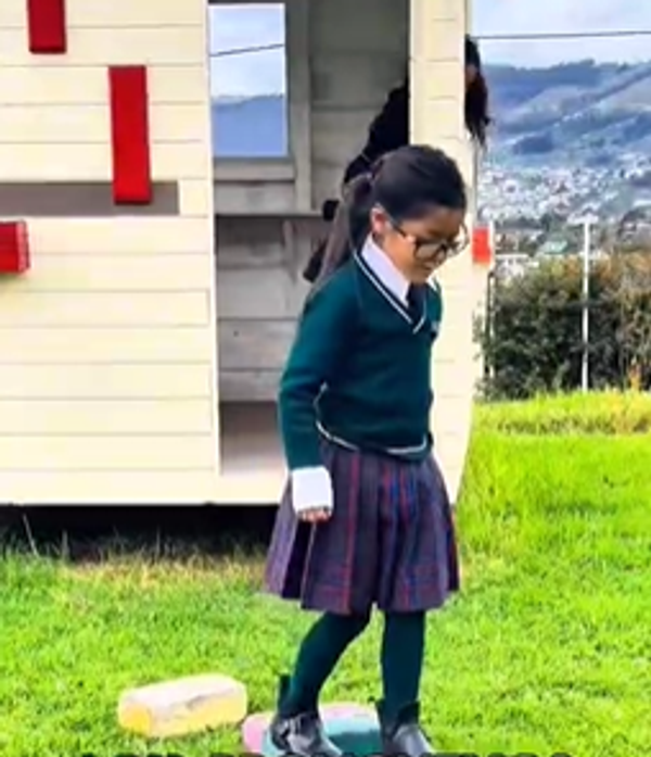 Niños corriendo en el patio de césped de la institución
