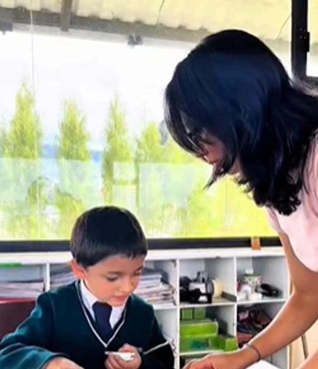 Voluntario interactuando con estudiantes en una actividad de clase.