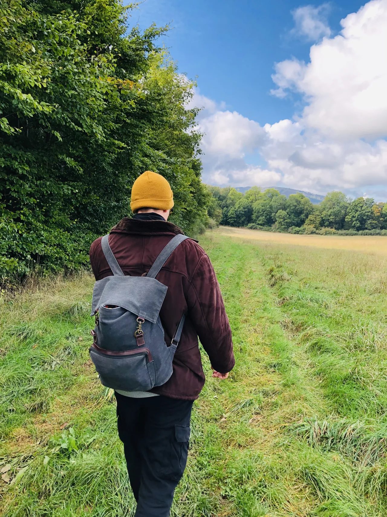 Kevin Otto Lais mit Rucksack auf einem Weg am Waldrand