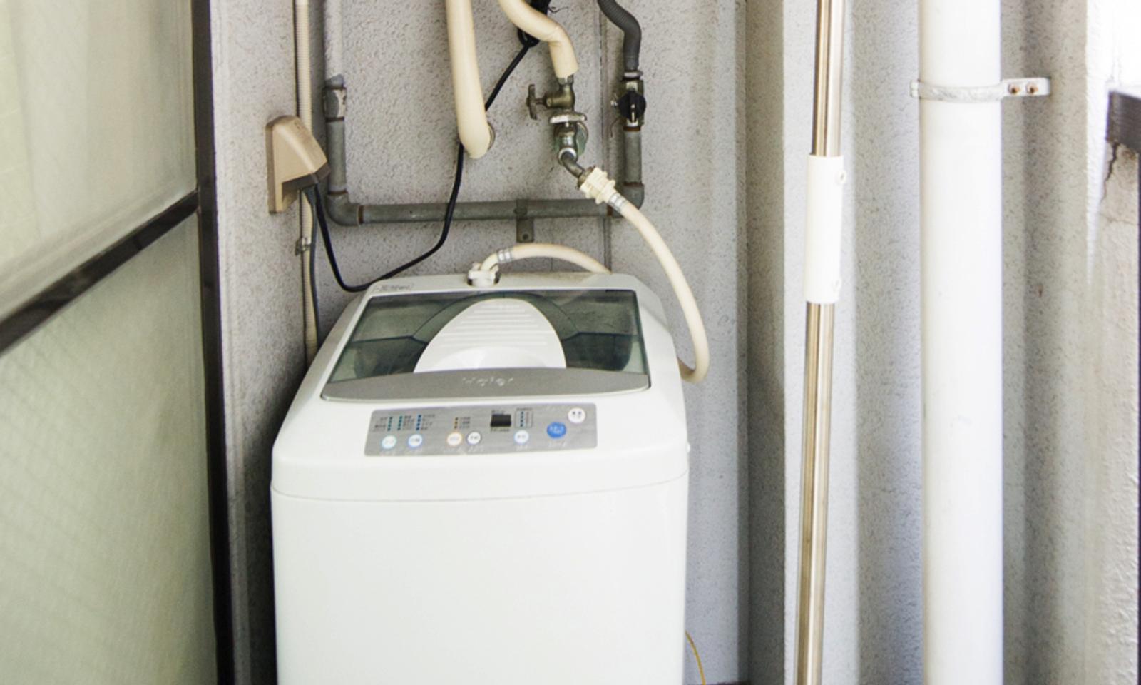 There is a washing machine in the balcony.