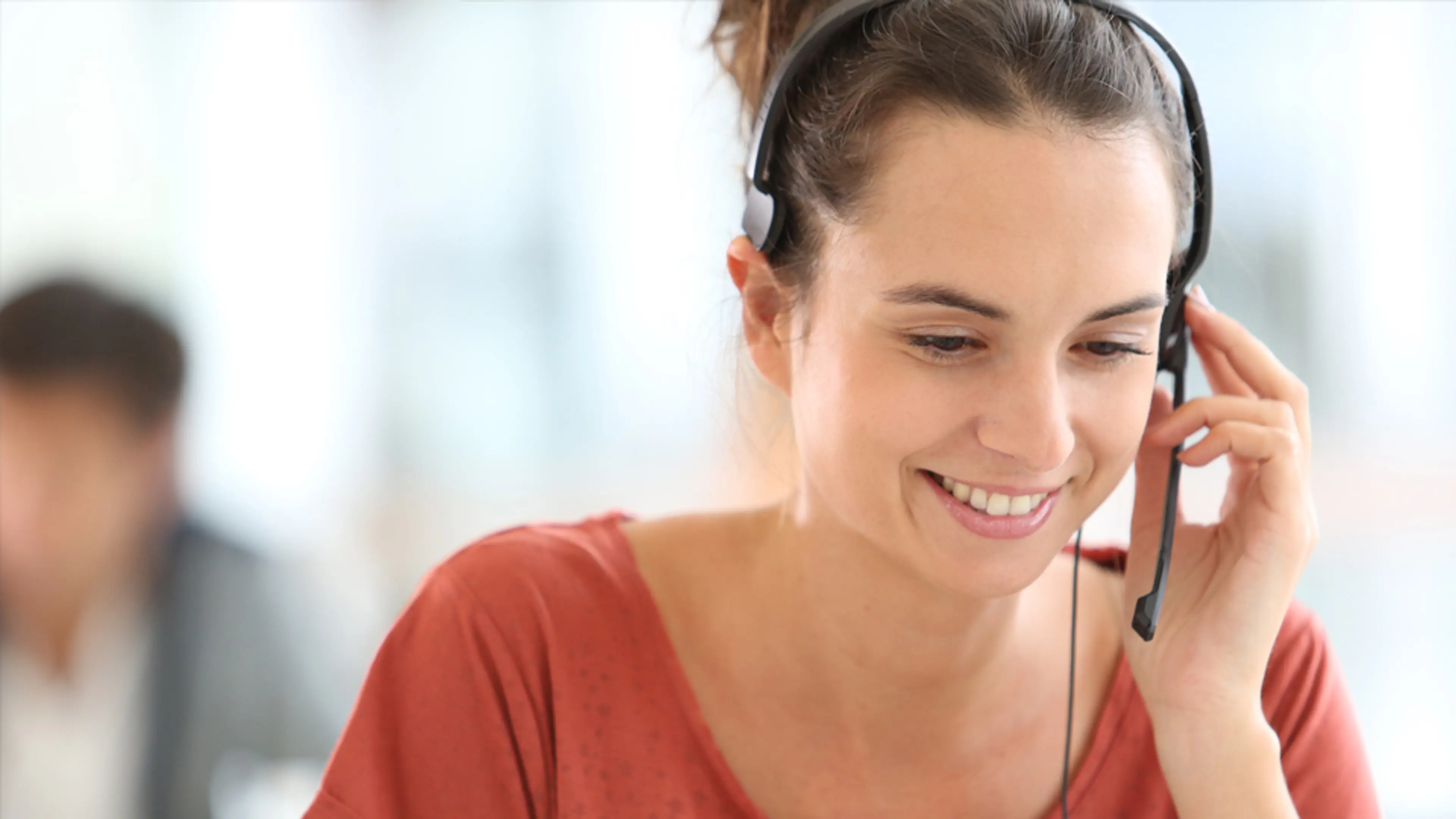 Ung dame som sitter og snakker i telefon via headset