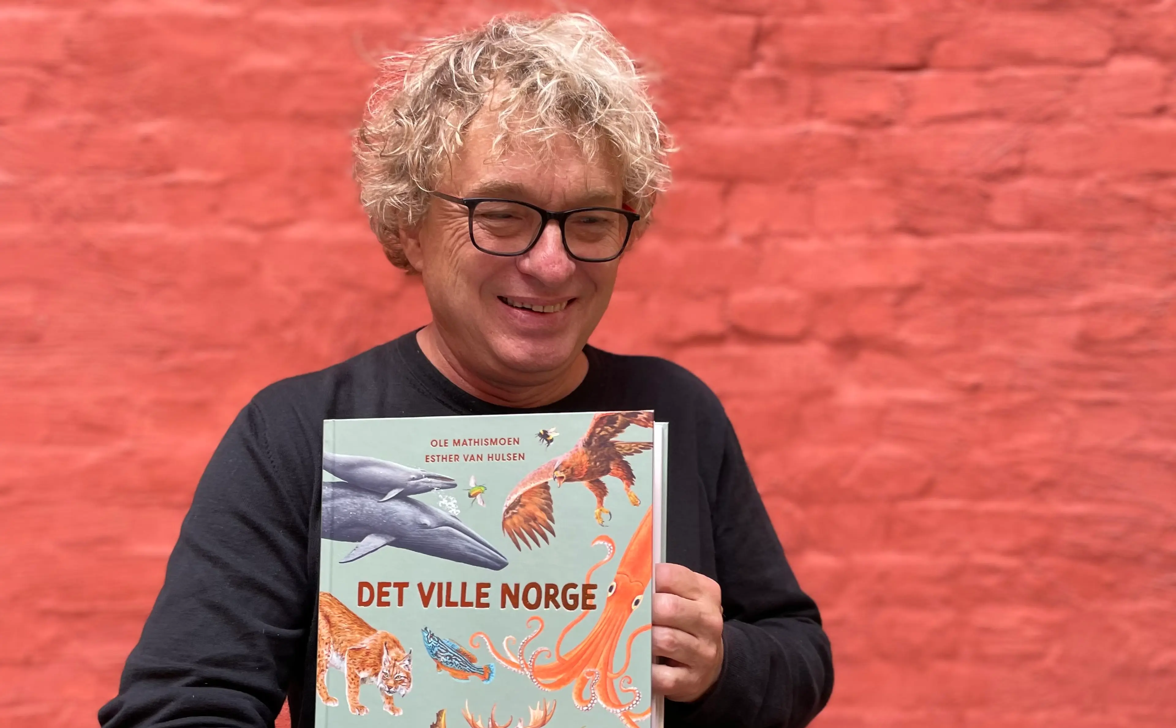 Ole Mathismoen med boken Det ville Norge