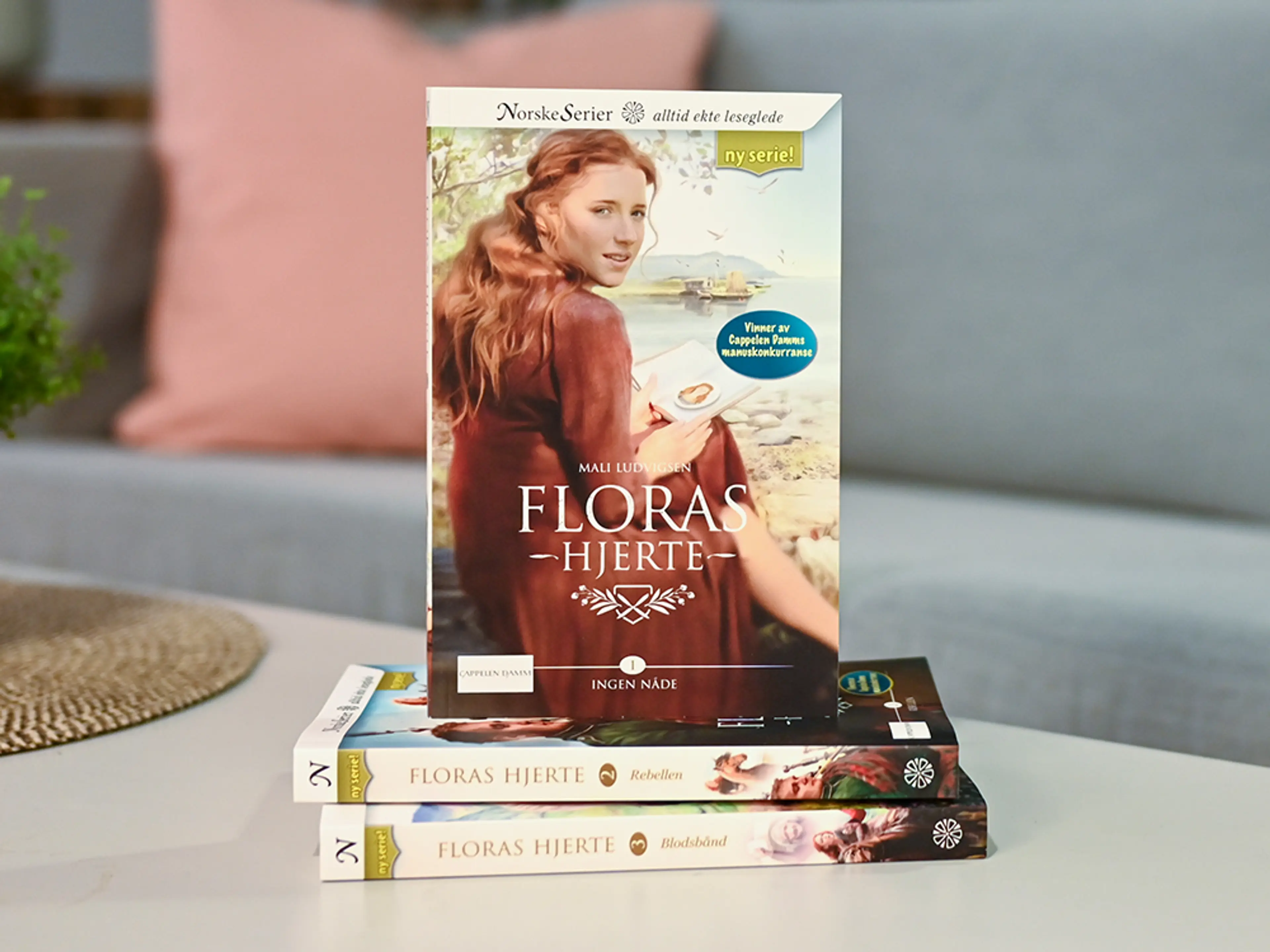 Bilde av de tre første bøkene i romanserien Floras hjerte