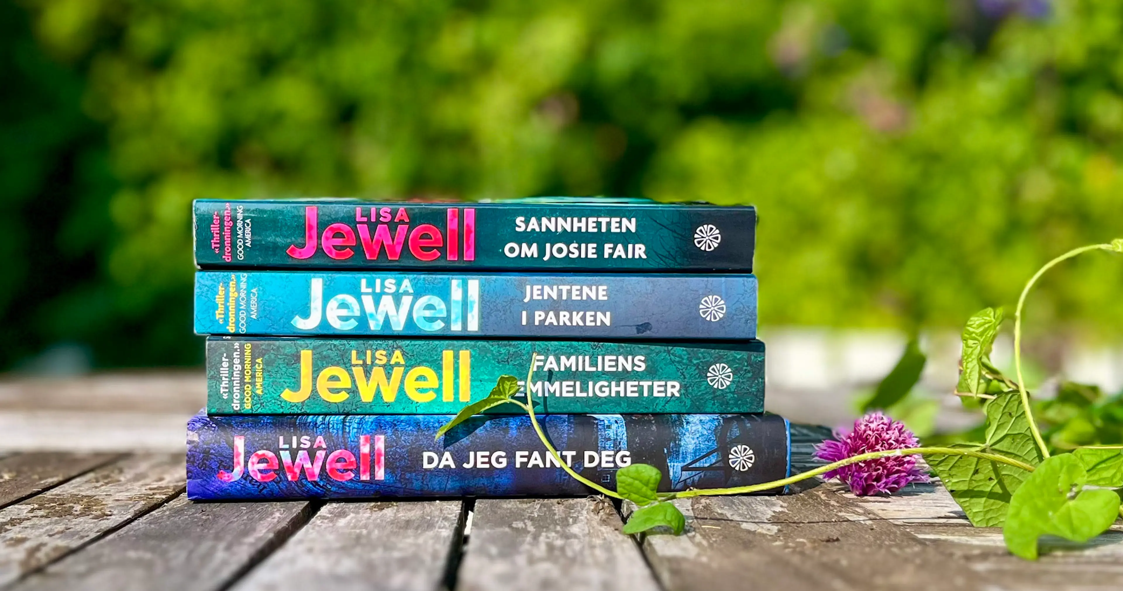 Fire bøker av Lisa Jewell liggende på et bord med grønne blader ved siden av