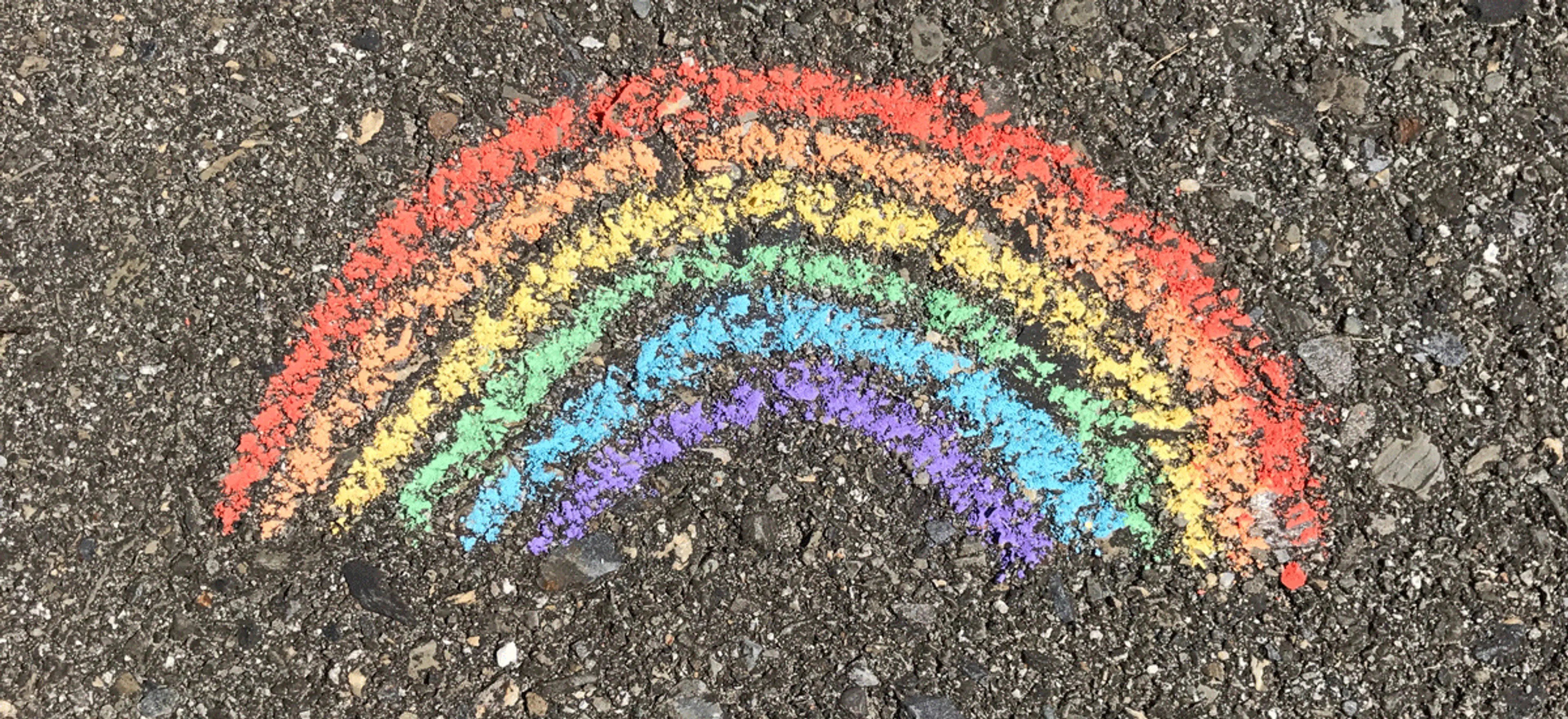 Prideflagget tegnet med kritt på asfalt
