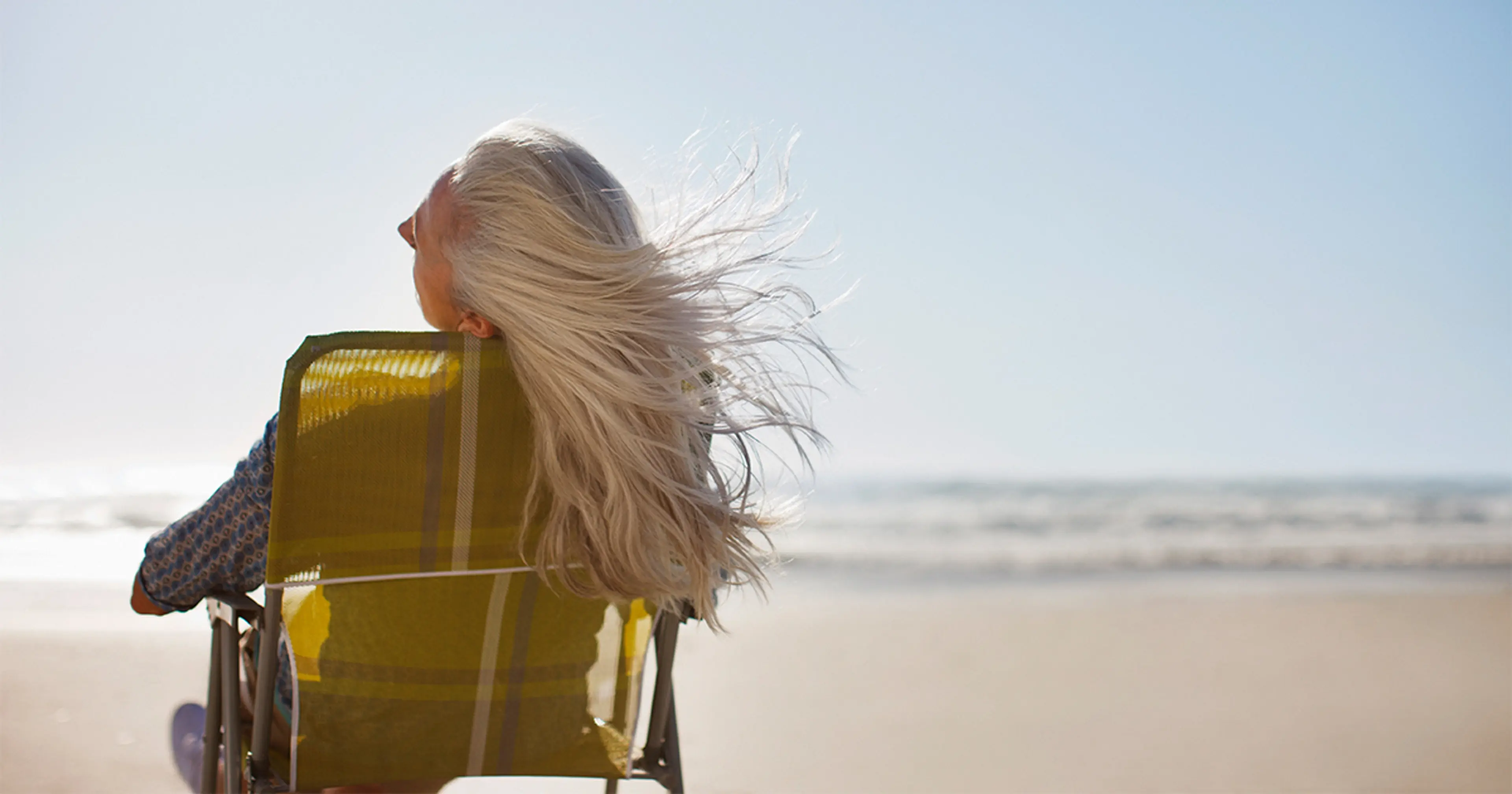 Dame på en strand med flagrende hår