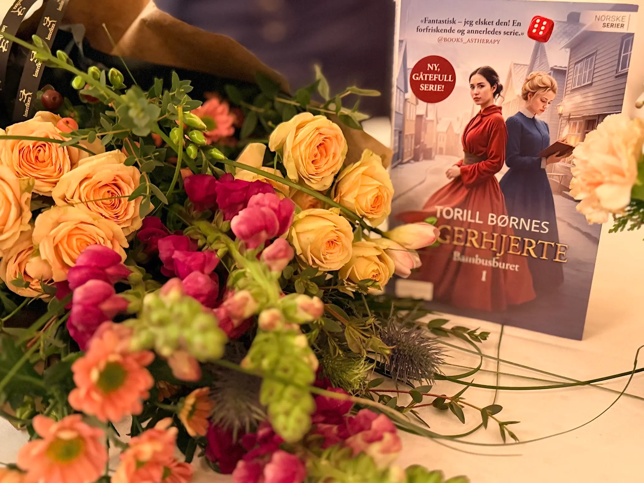 Bilde av blomster og første bok i romanserien Tigerhjerte