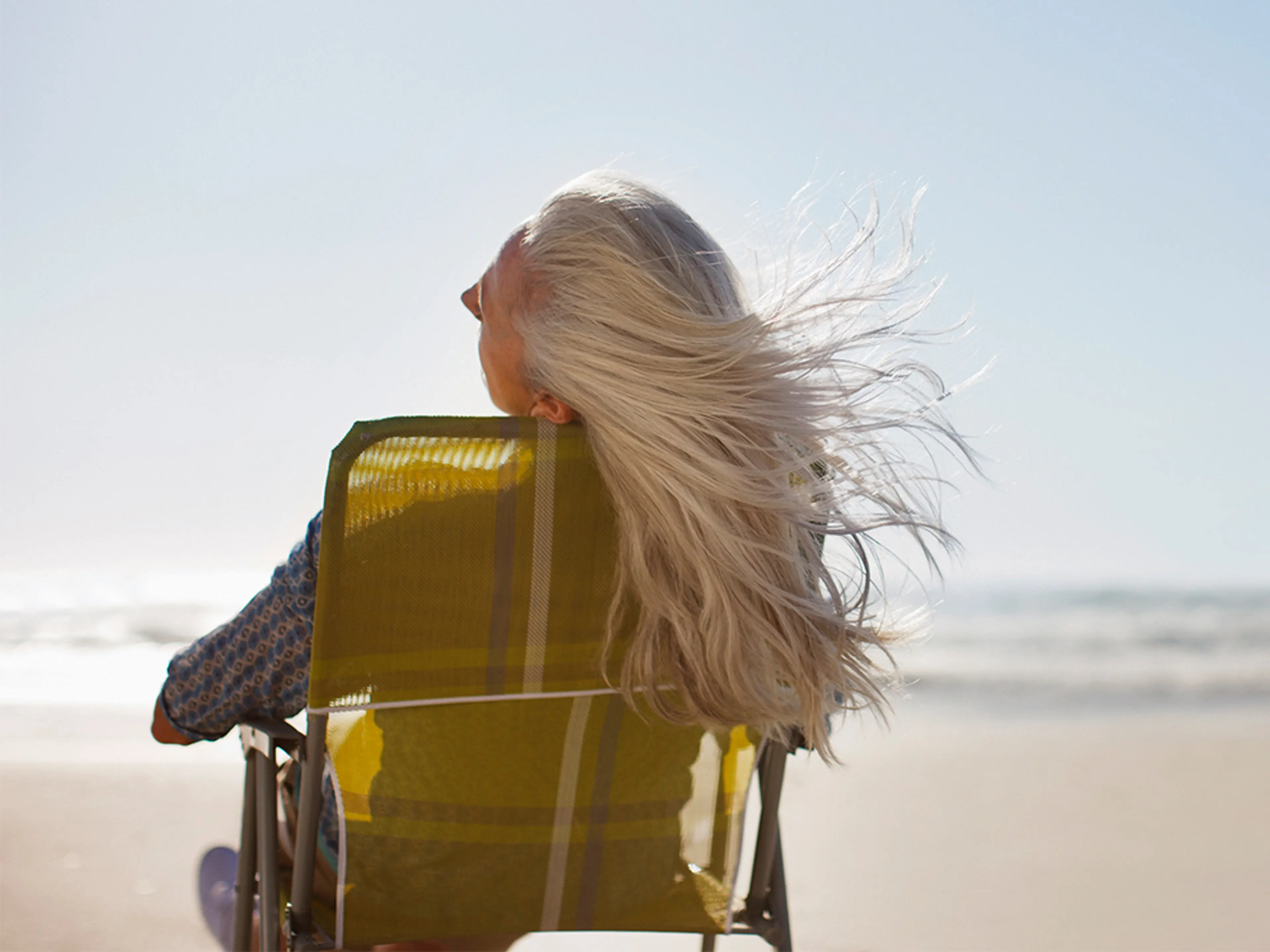 Dame på en strand med flagrende hår