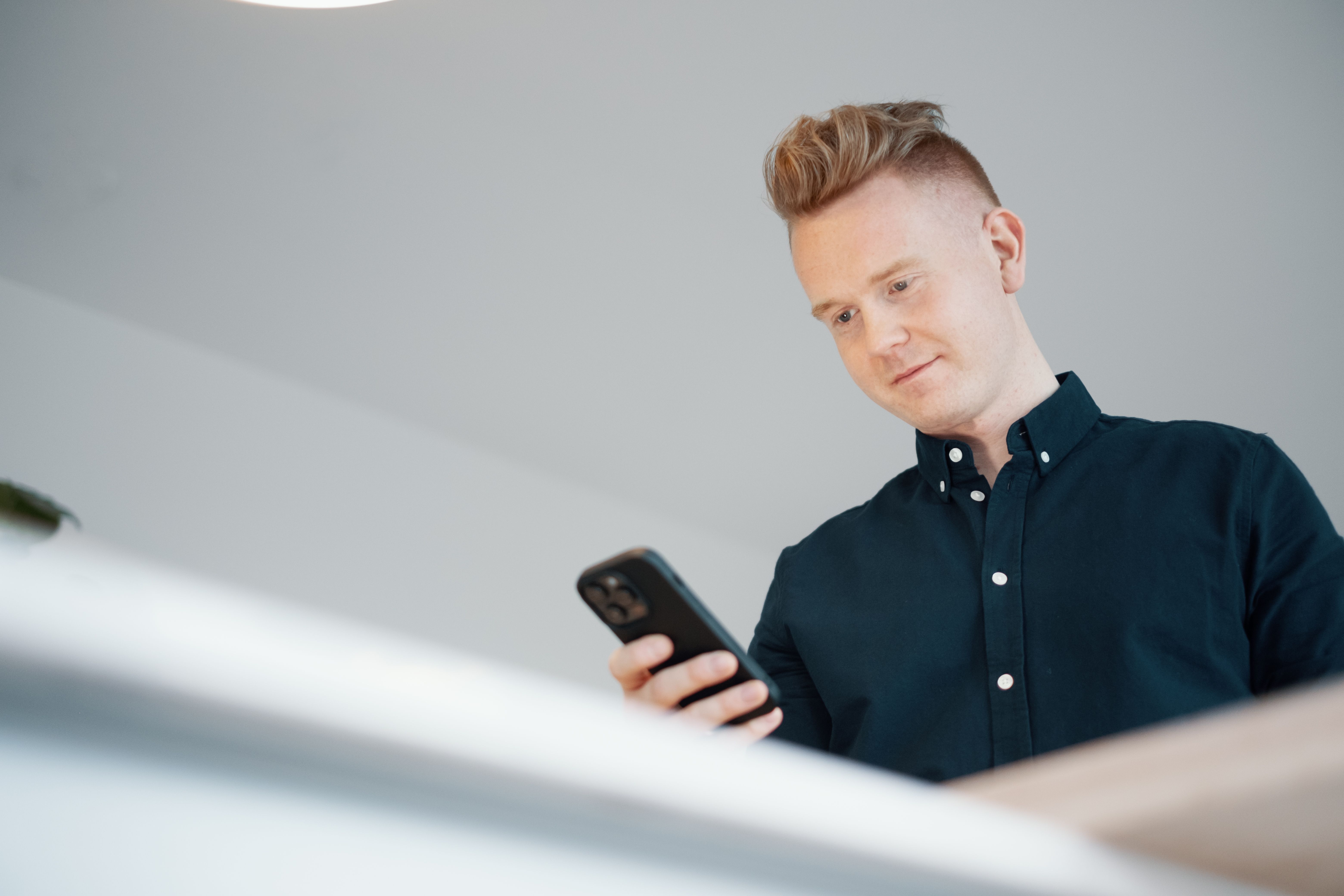 Mann som leser på mobiltelefon