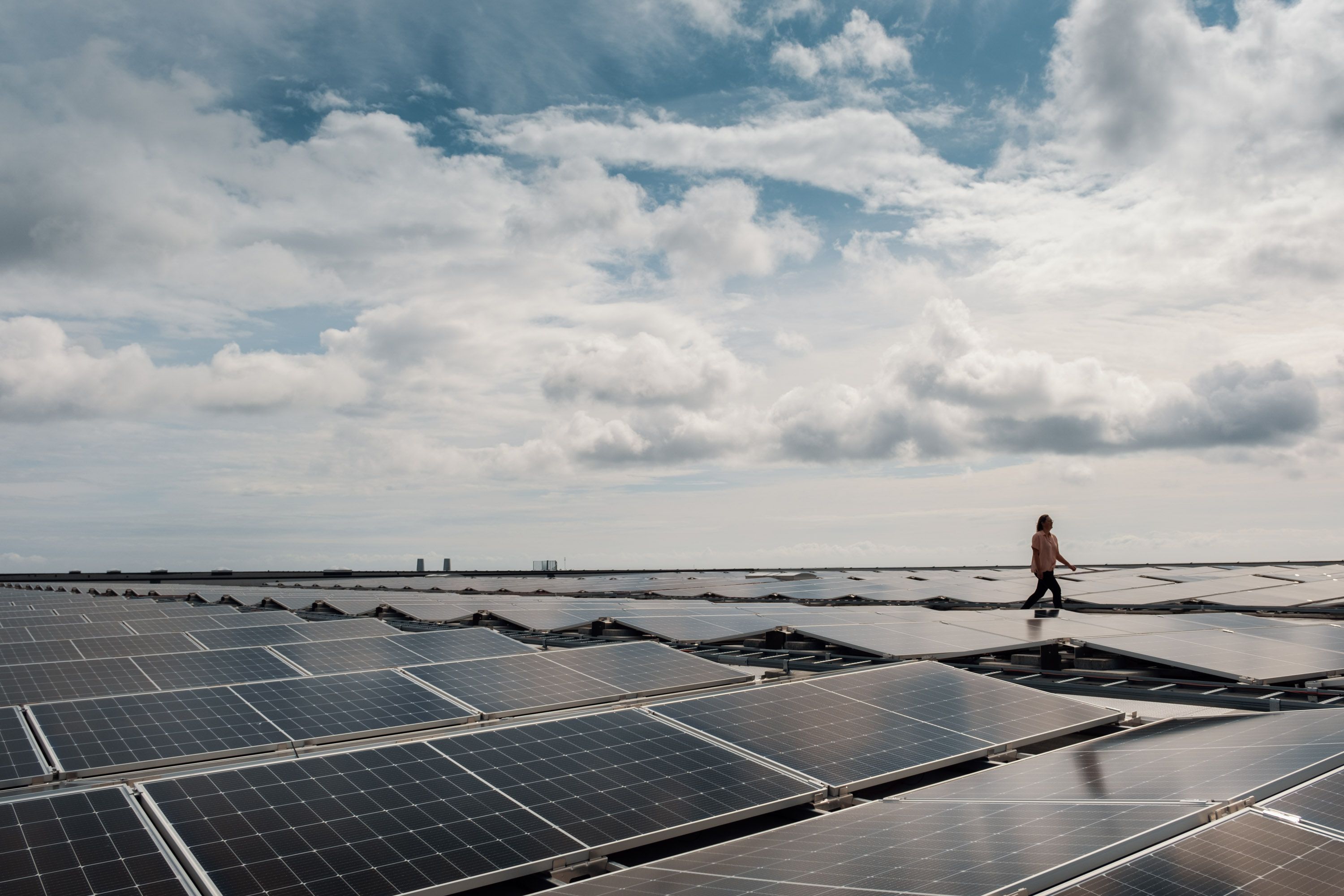 person som spaserer på tak med mange solceller