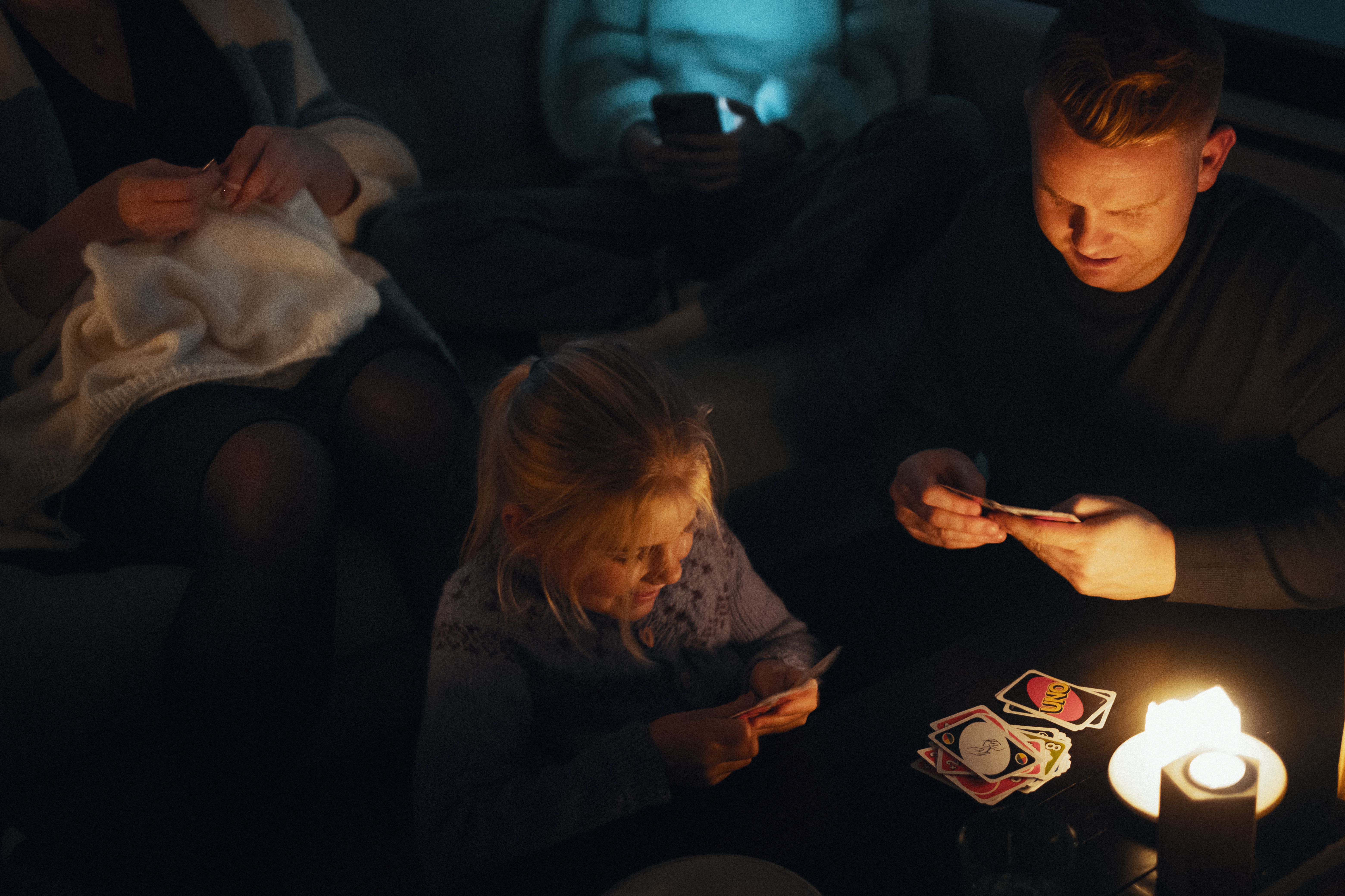 Far og datter spiller kort i mørket