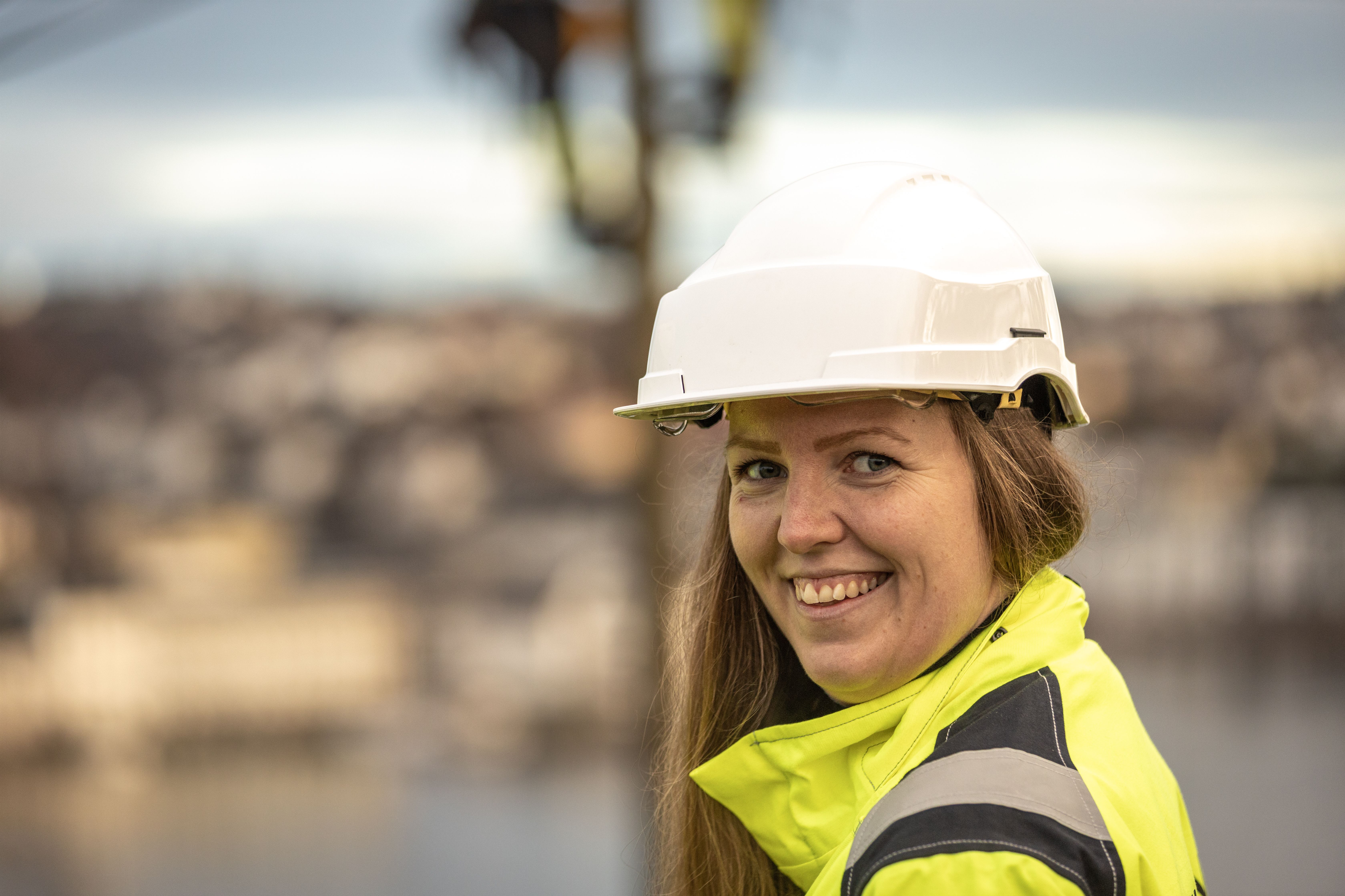 Nærbilde av dame med hjelm og arbeidstøy