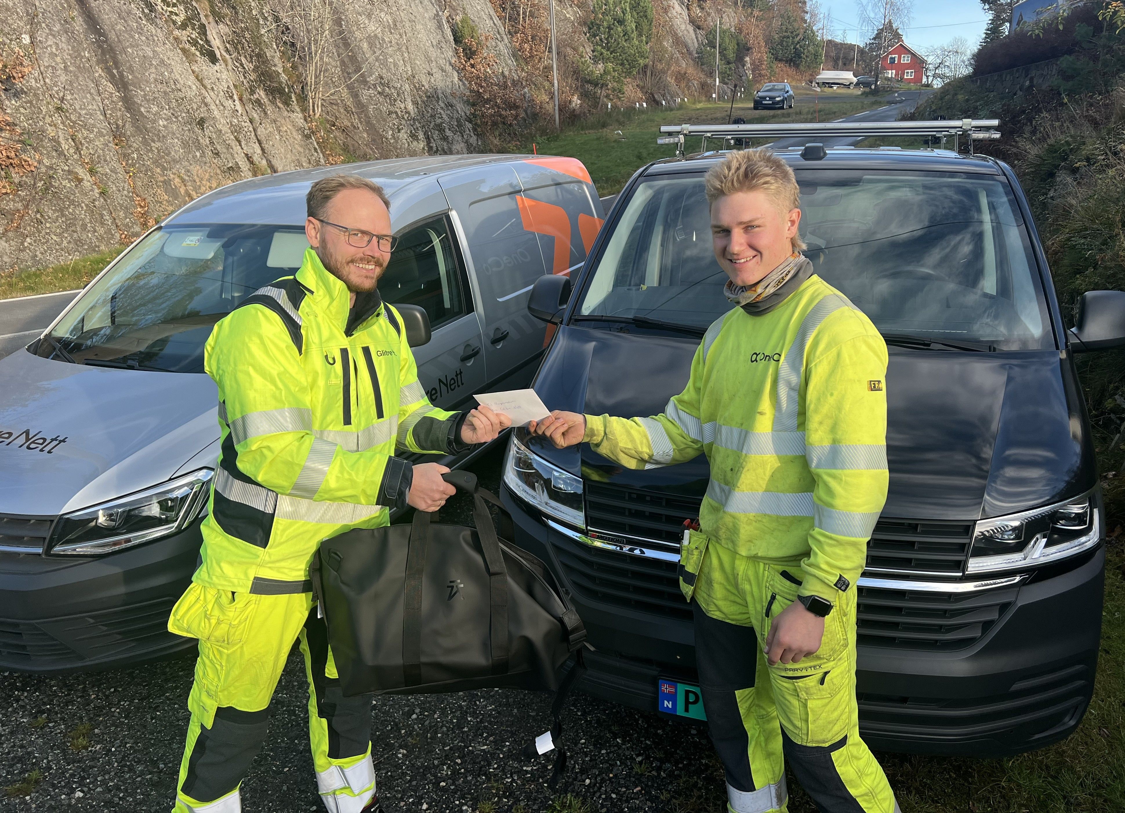 Montører ute foran arbeidsbiler