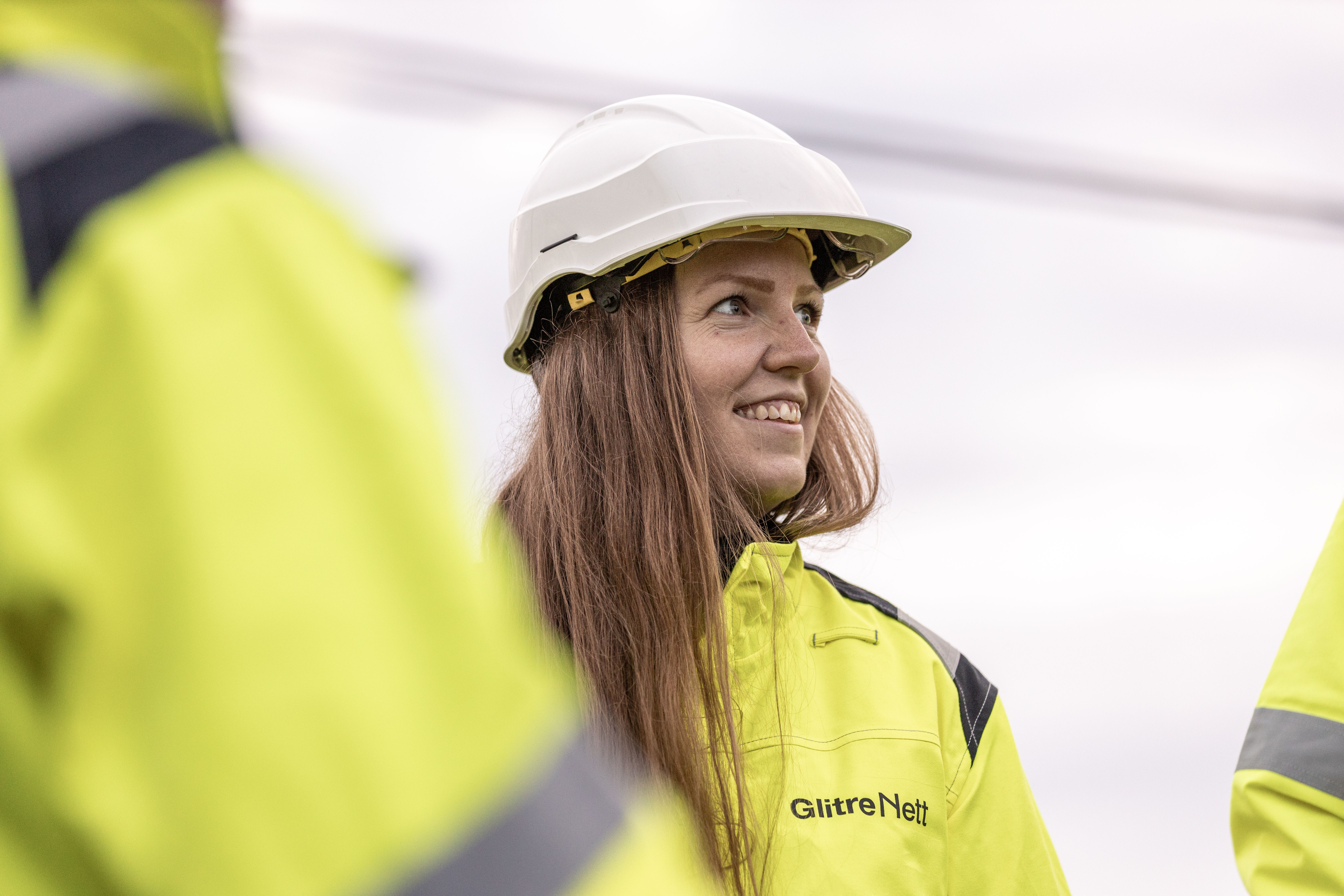 4 Glitre Nett arbeidere ute på jobb. 2 stykker i toppen av en mast. 