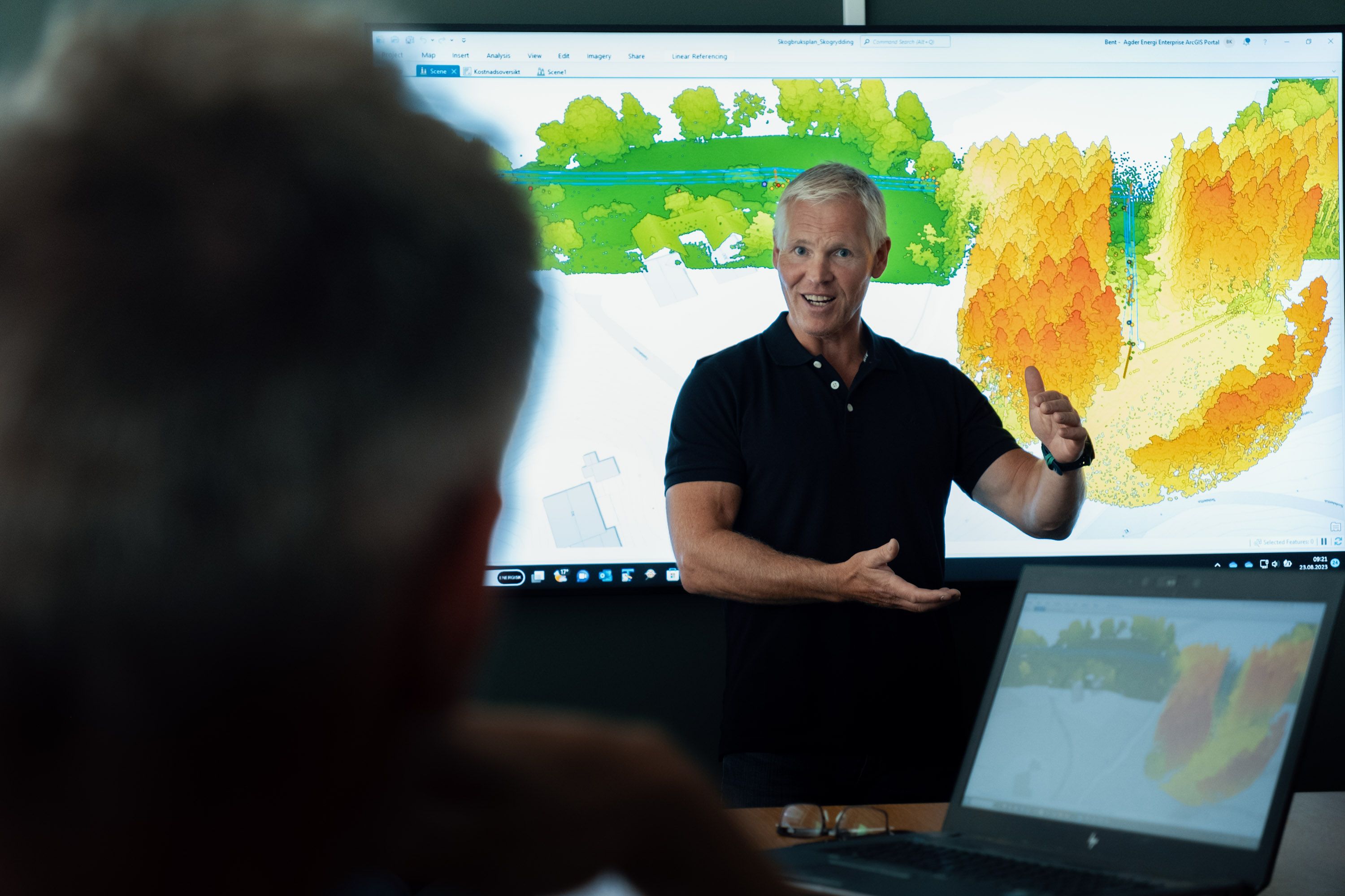 Mann som demonstrere ny teknologi, med fargekart i bakgrunnen