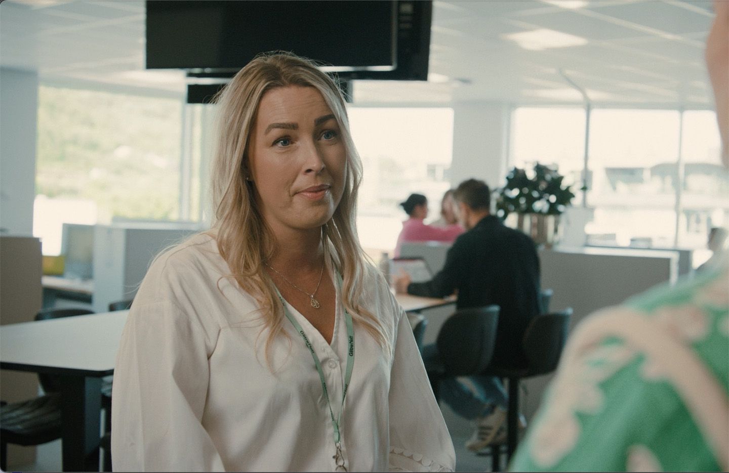 Dame med kontorlandskap i bakgrunnen