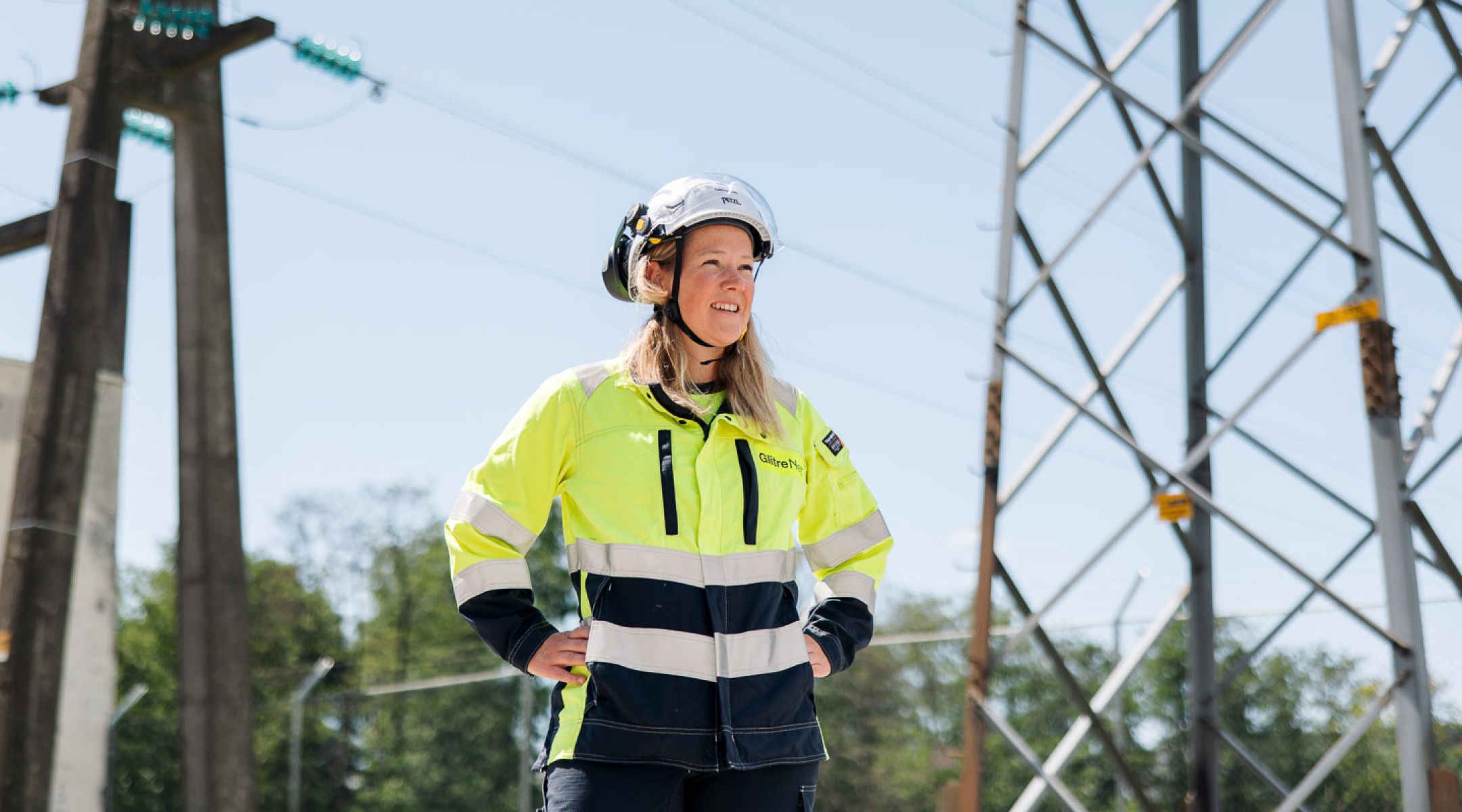 Dame i arbeidsklær ved strømnett