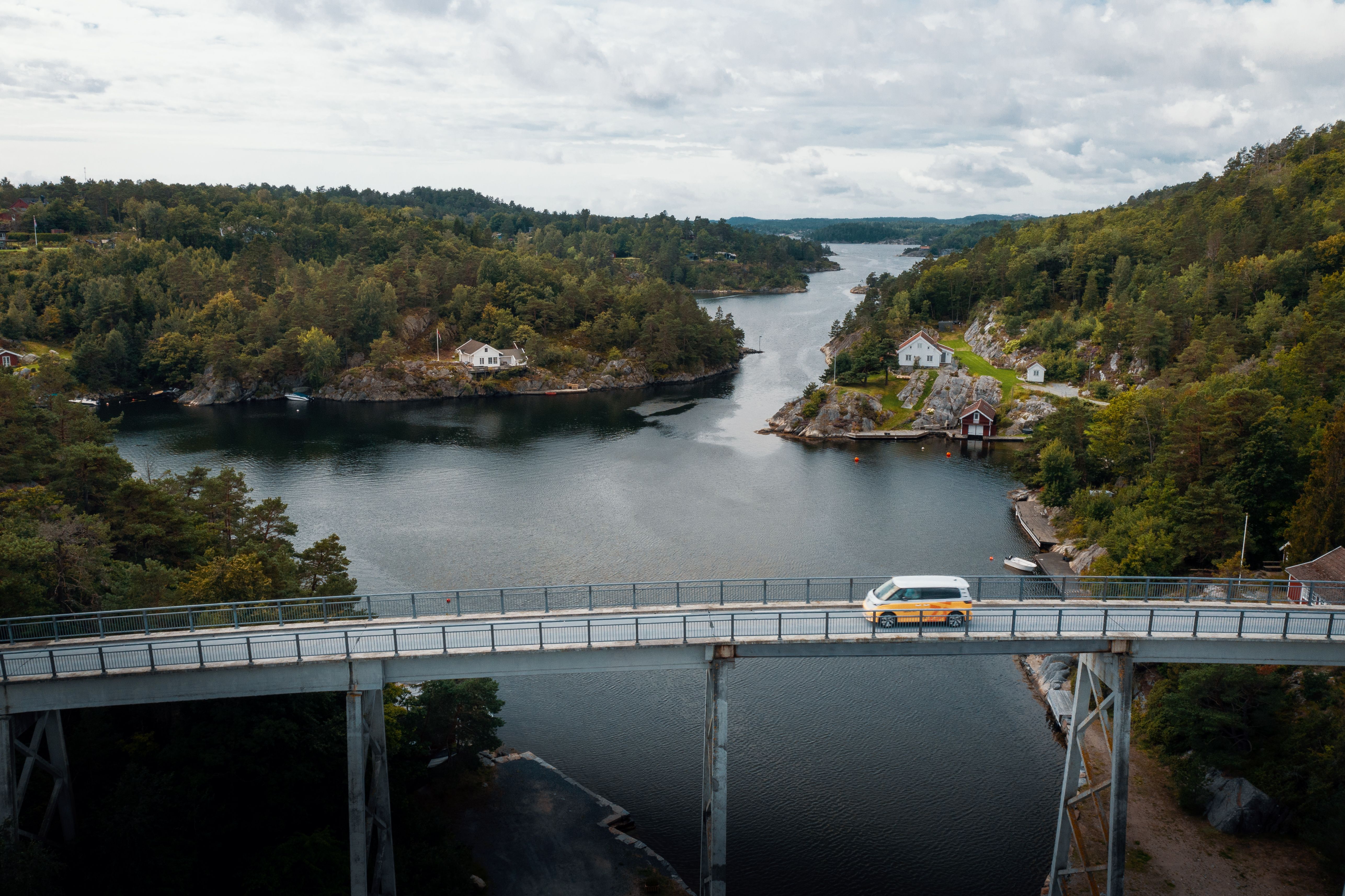 Glitre Nett bil kjører over en bro, over et vann. 