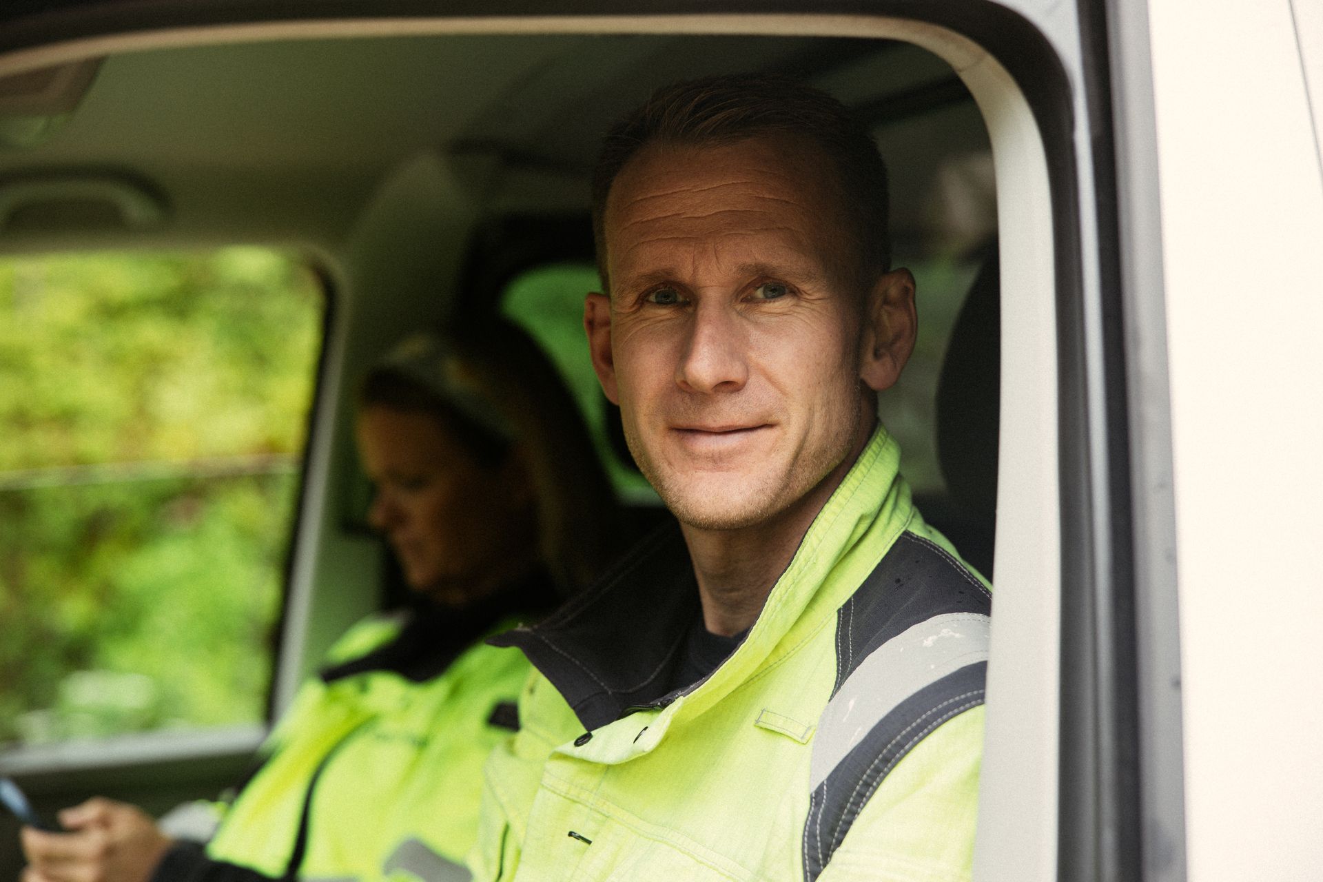 Nærbilde av mann med arbeidstøy i bil.