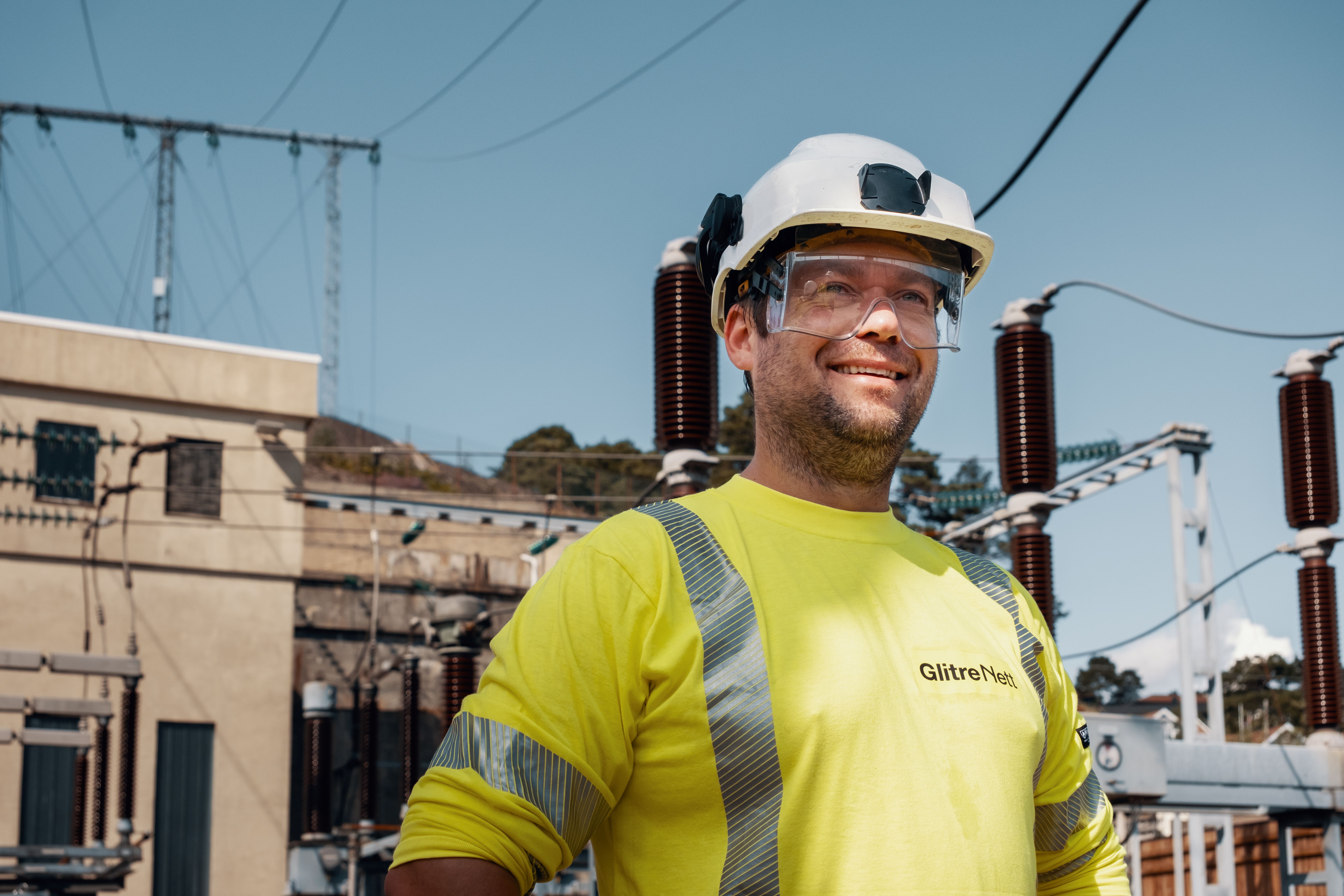 Mann, energimontør foran trafostasjon