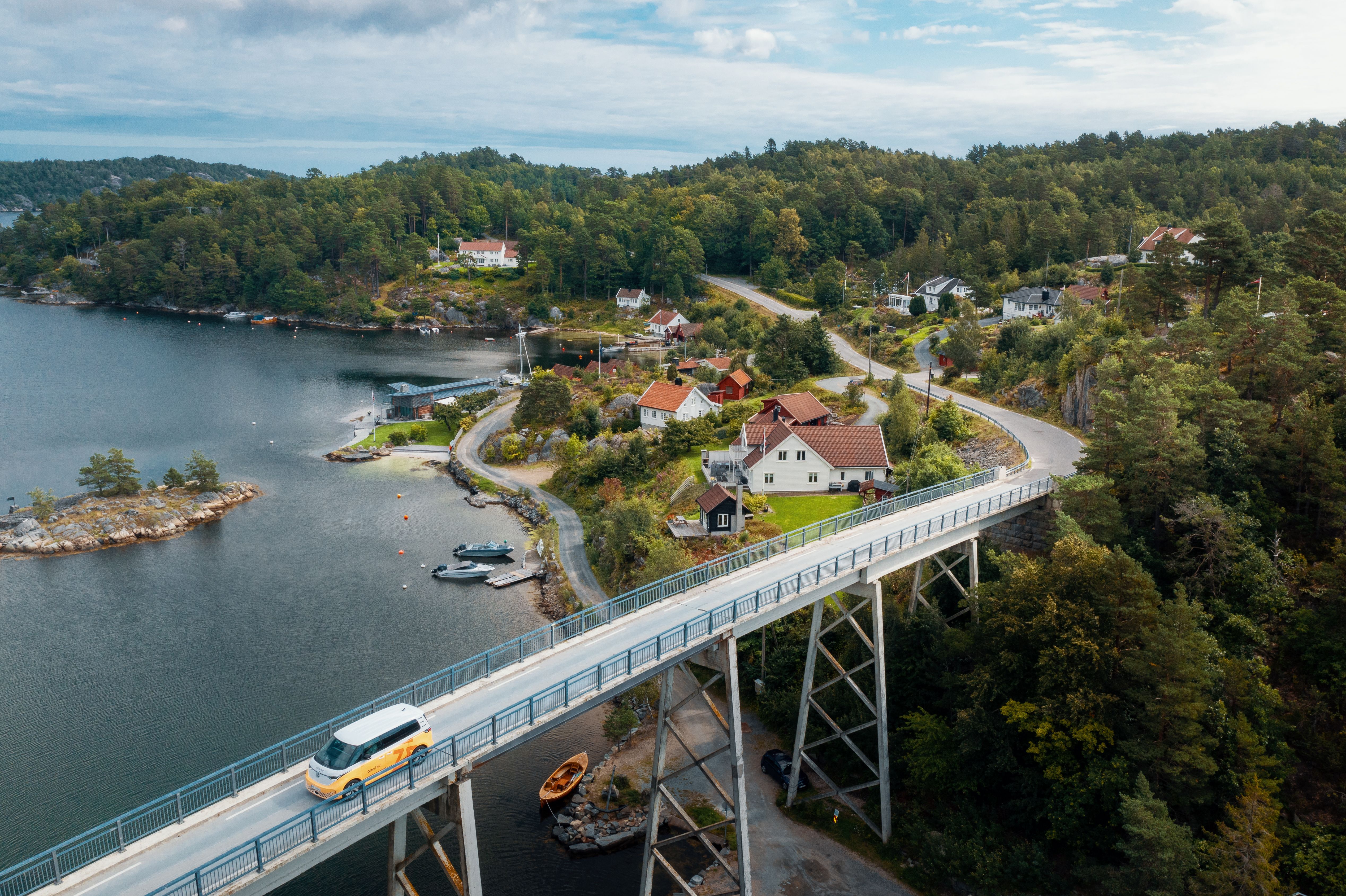 Glitre Nett bil kjører over en bro på sørlandet. 