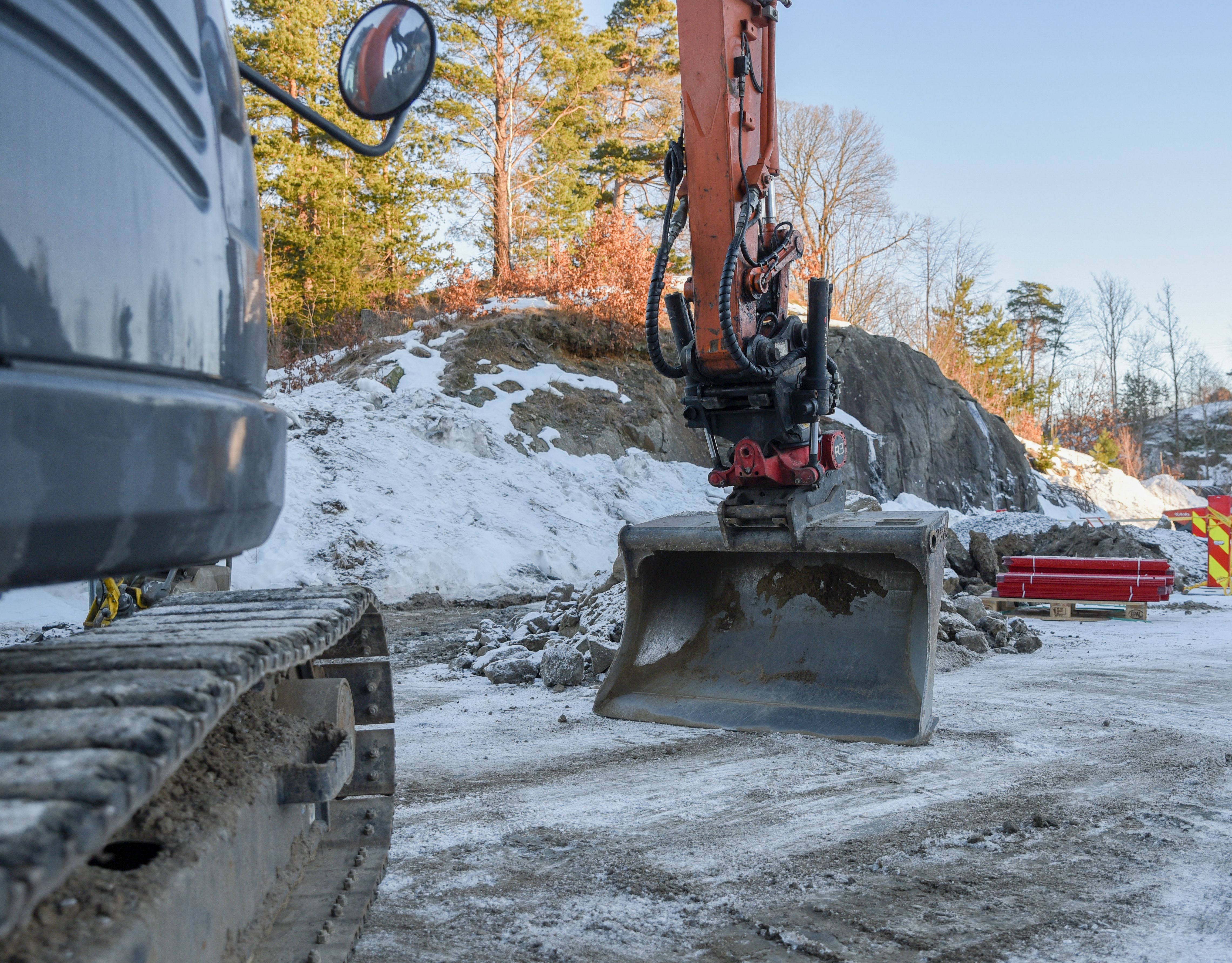 Gravemaskin som graver en tidlig vinter. 