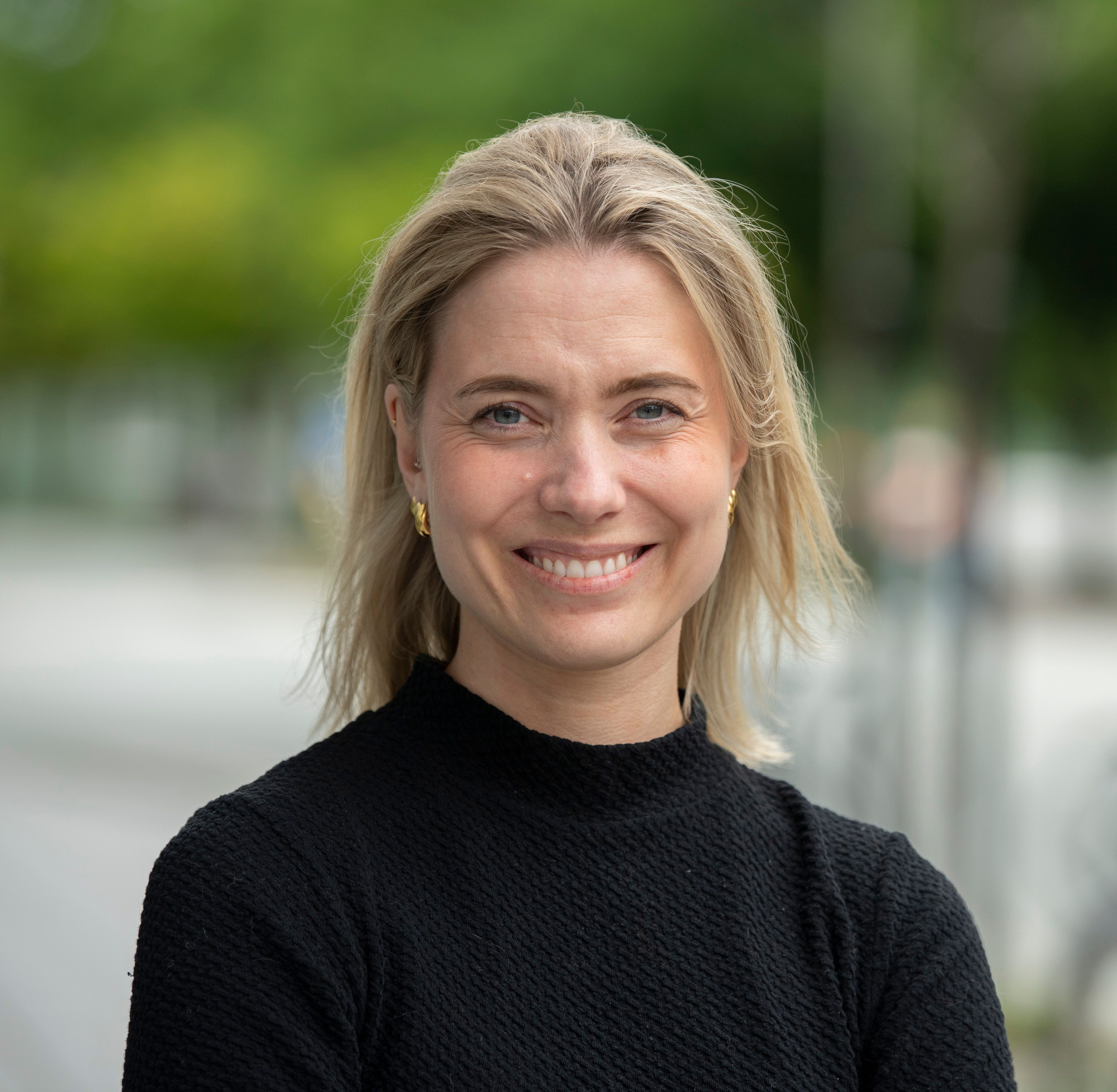 Profilbilde av dame smilende i svart genser