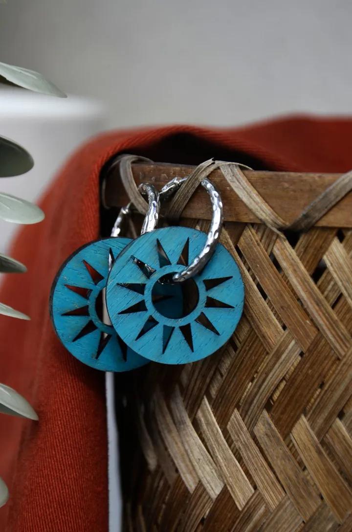 Pendentifs turquoise ajourés en rayons, accrochés à un panier en osier