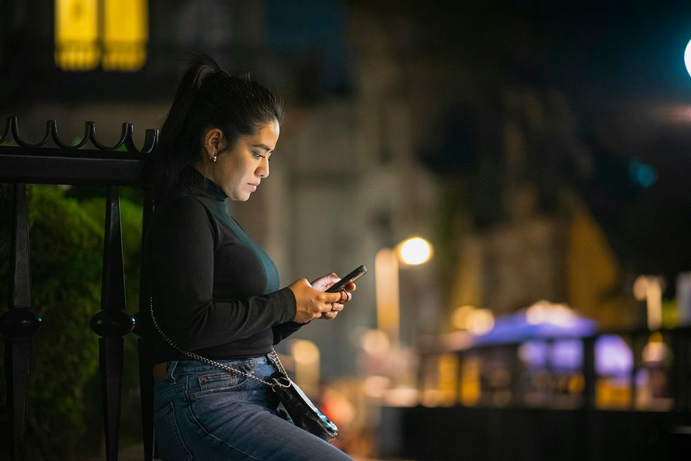 Mujer viendo una miniserie en el móvil de noche