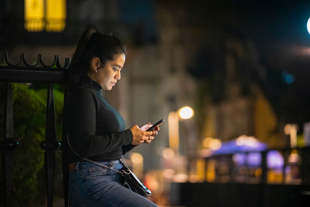 Mujer viendo una miniserie en el móvil de noche