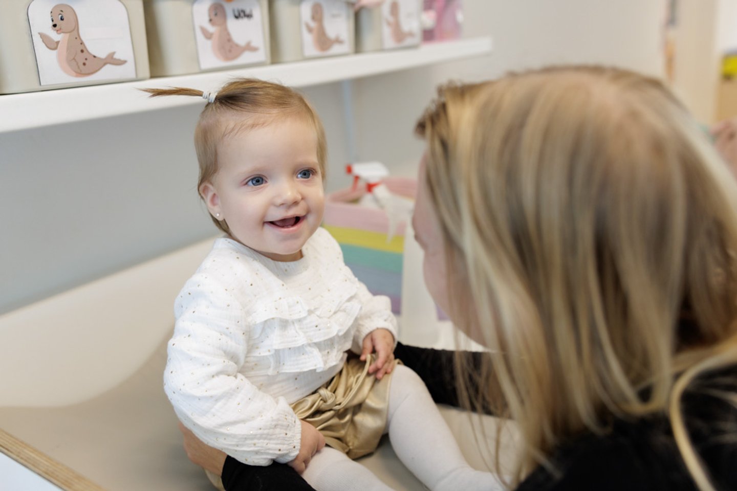 lachende baby met pedagogisch professional