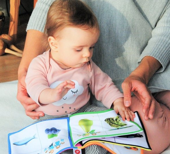 Baby leest boekje op opvang